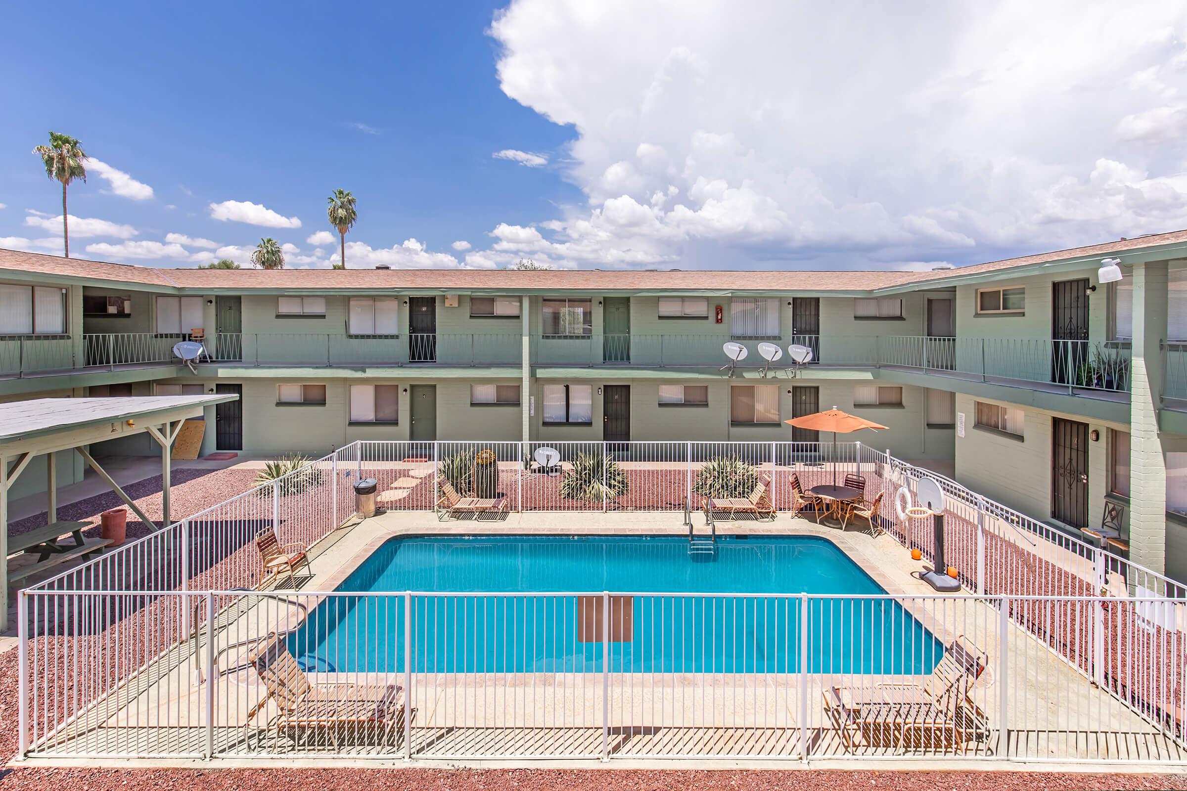 a building with a pool in front of a fence