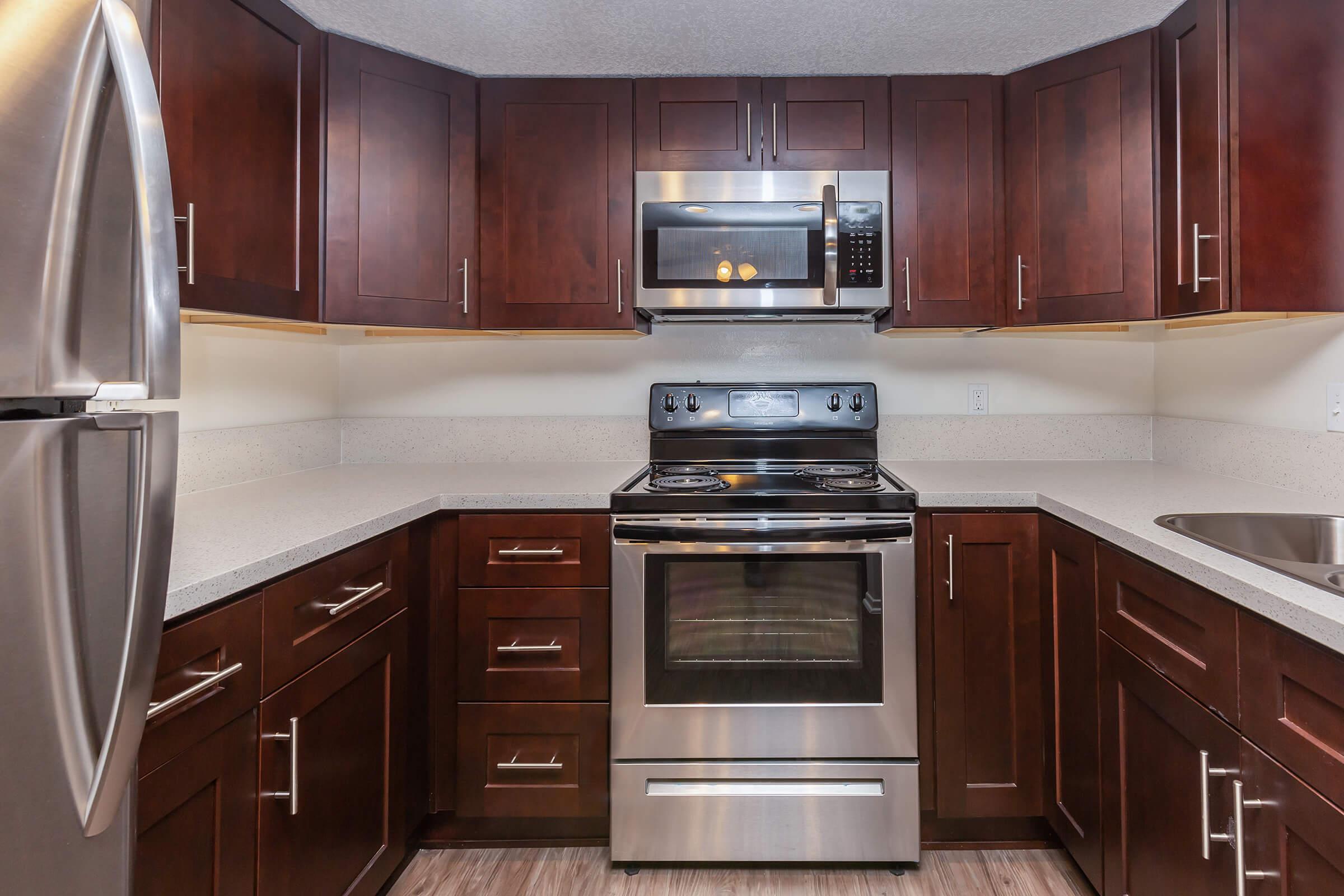 A kitchen with stainless steel appliances and wooden cabinets