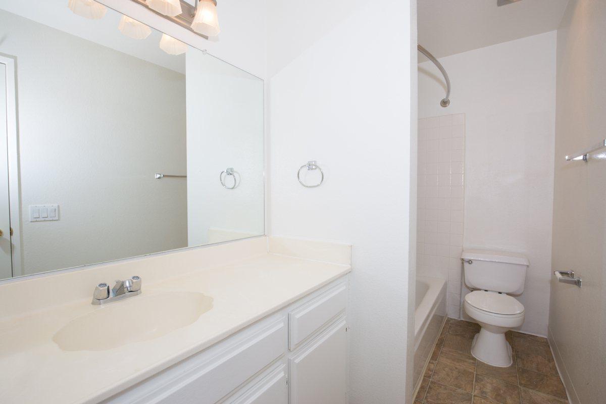 a white sink sitting next to a shower