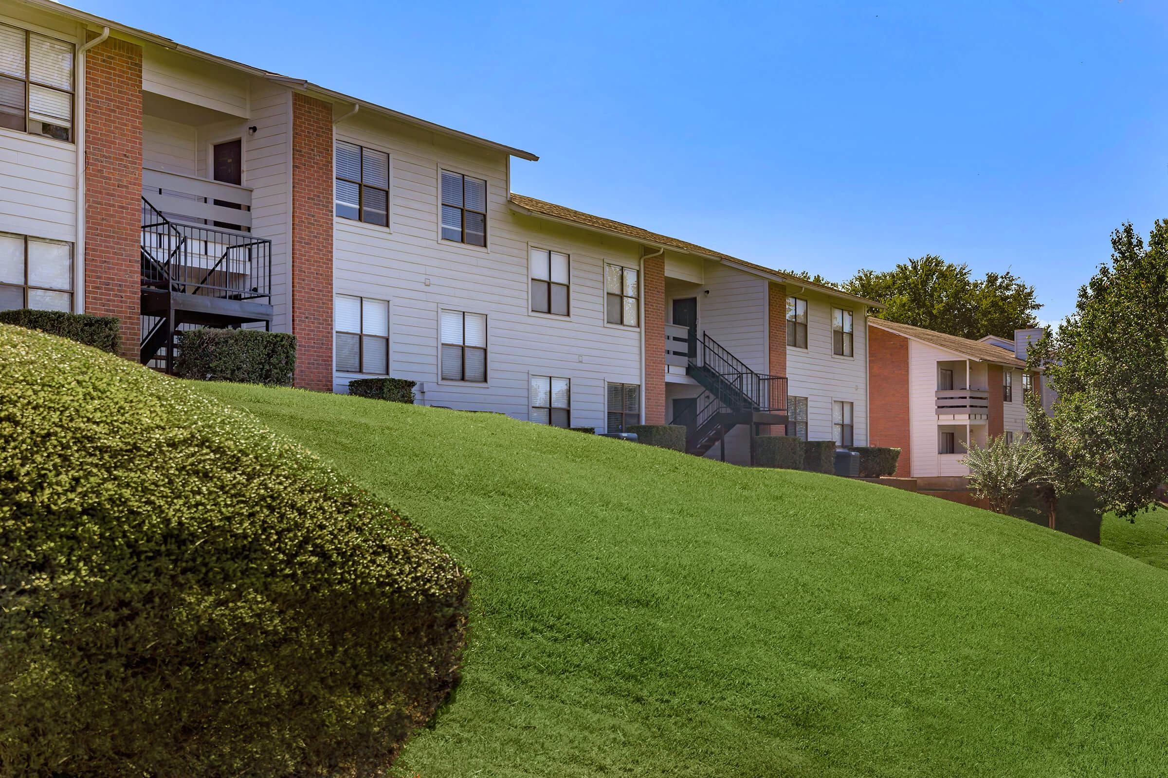 a large lawn in front of a brick building