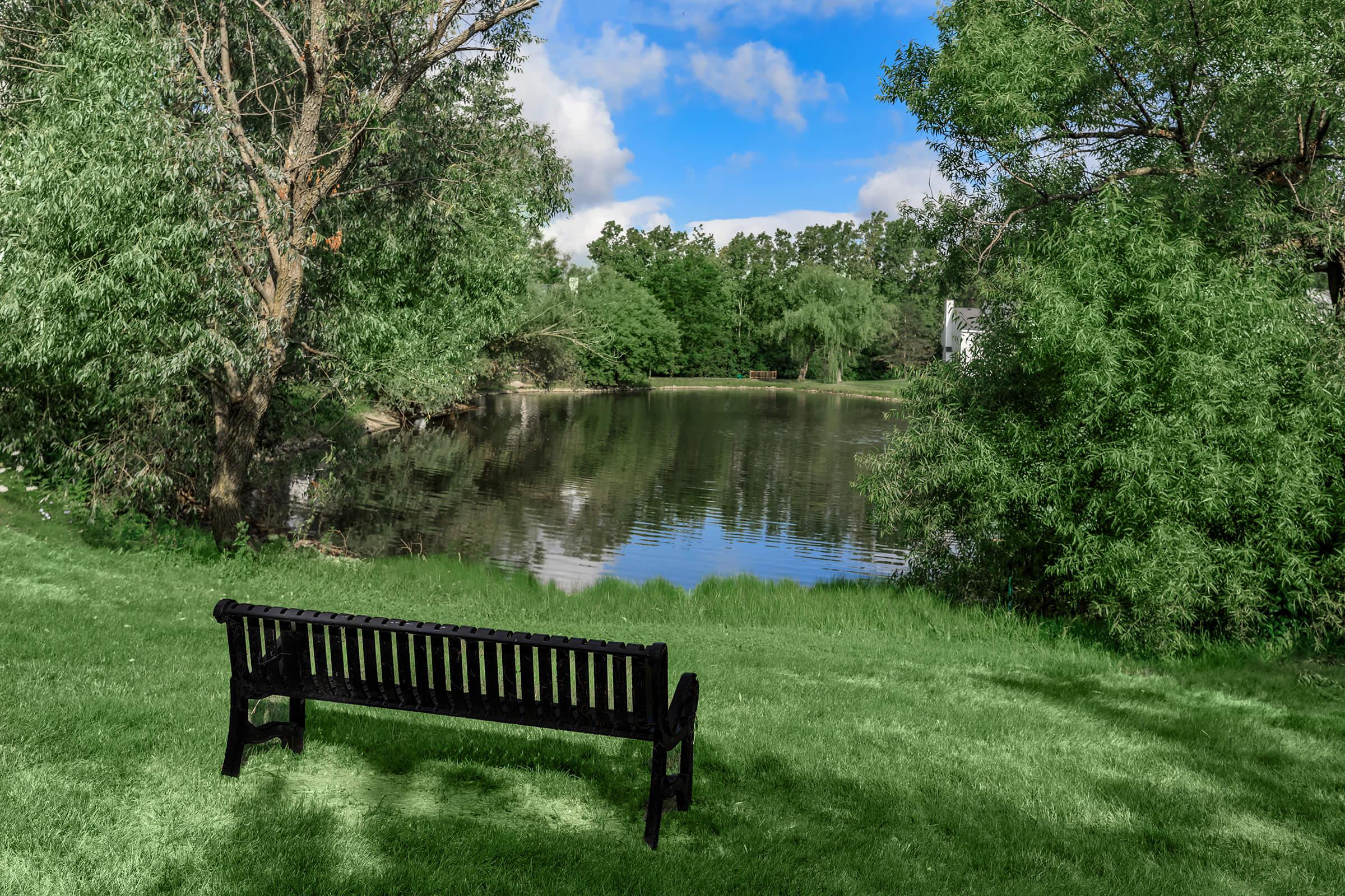 an empty park bench next to a body of water