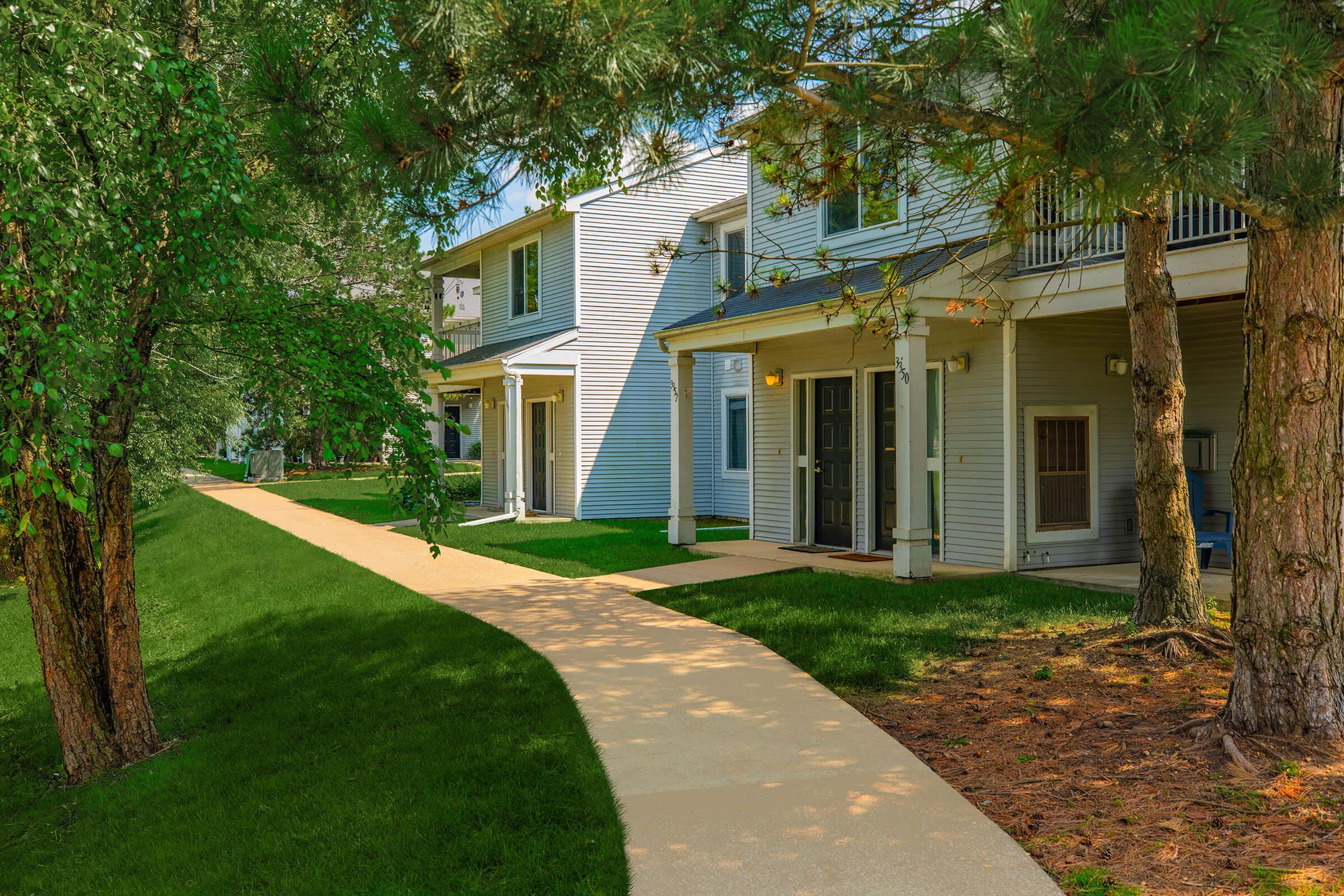 a house with a lawn in front of a brick building