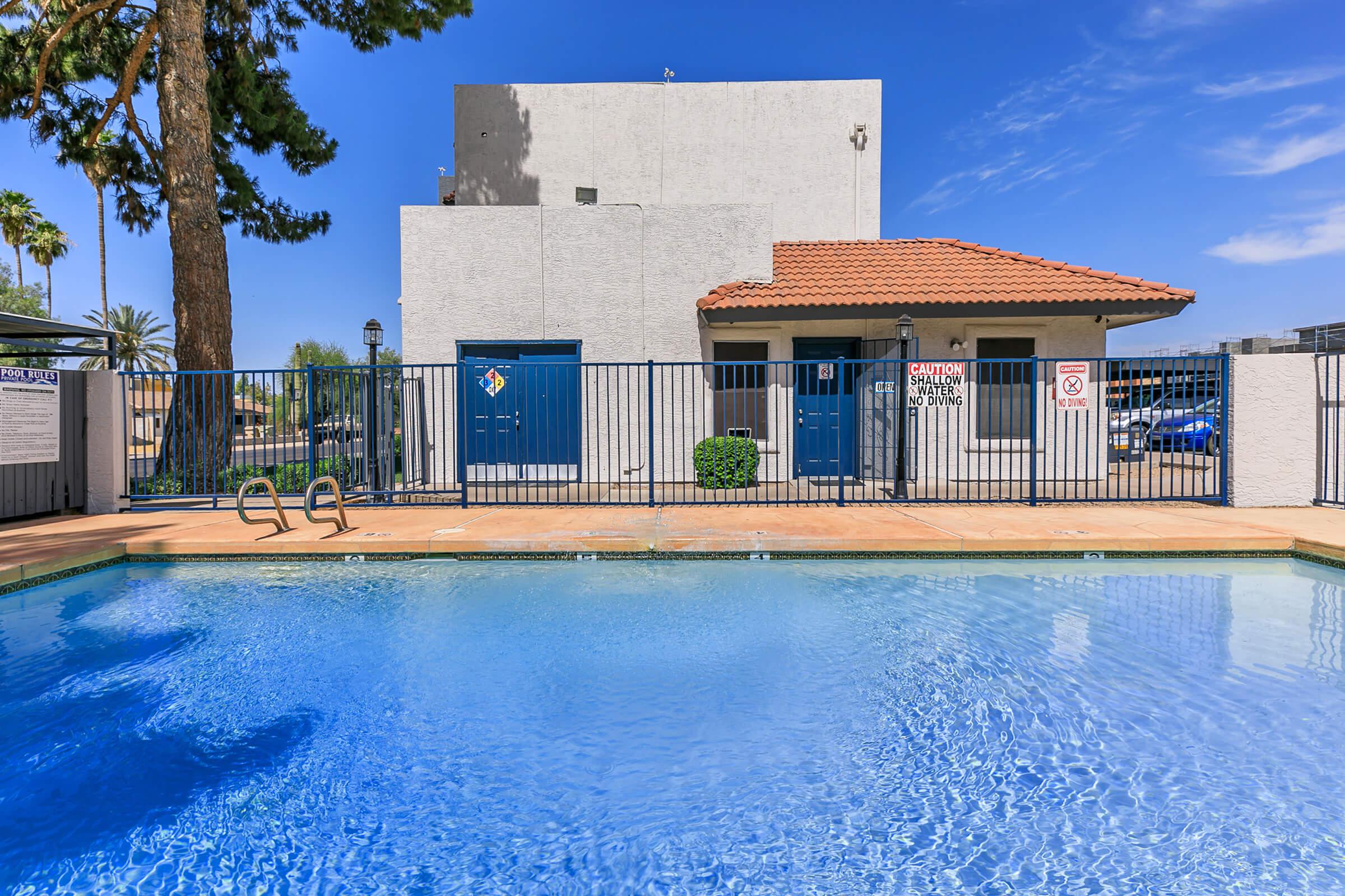 The pool area at Rise Trailside near a building. 