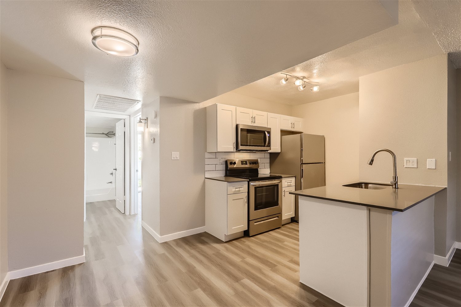 The kitchen and hallway leading to a bathroom at Rise Trailside.