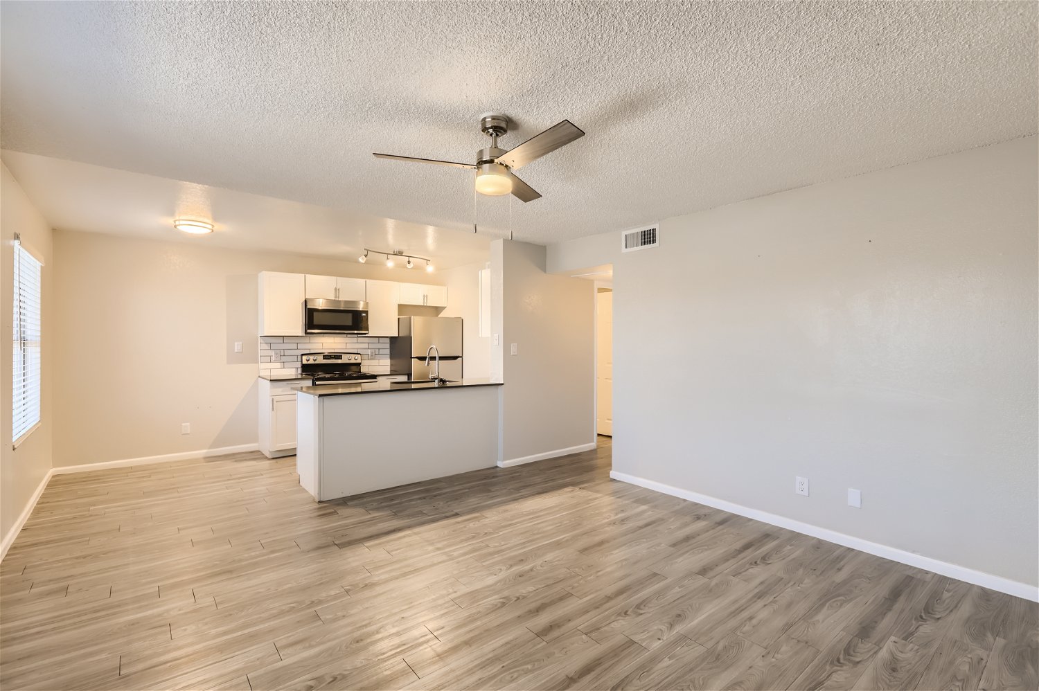 The open-concept living space with wood-style flooring at Rise Trailside.