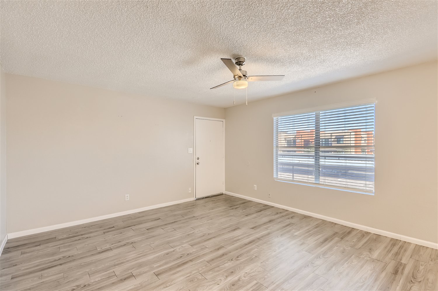 A large living room with a window in an apartment at Rise Trailside. 