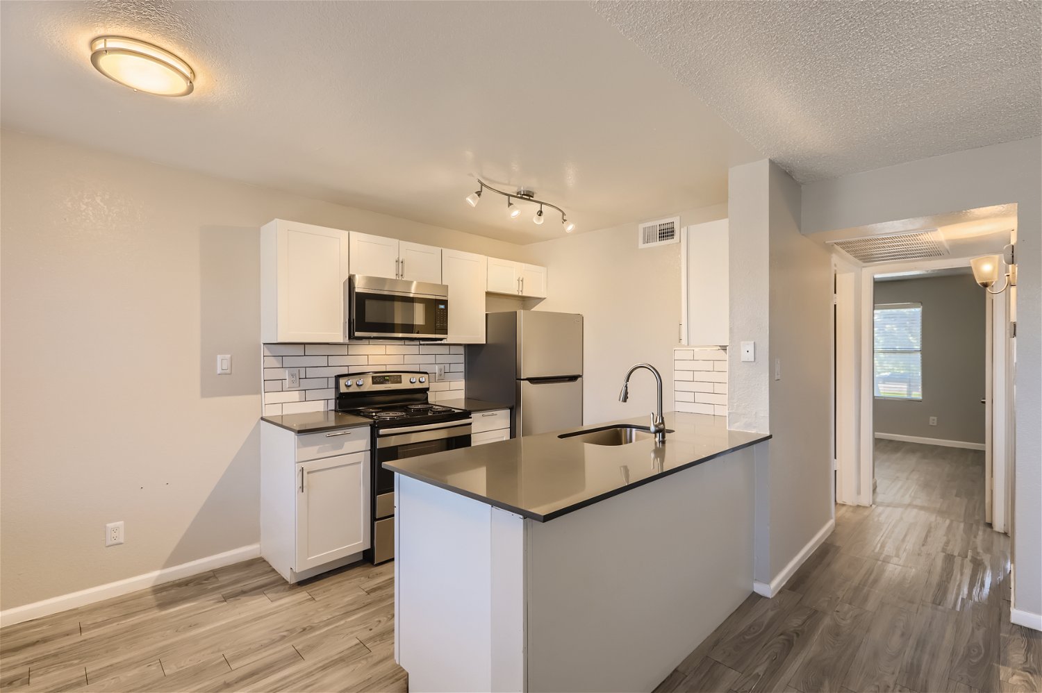 Rise Trailside apartment kitchen with grey quartz countertops and shaker cabinets