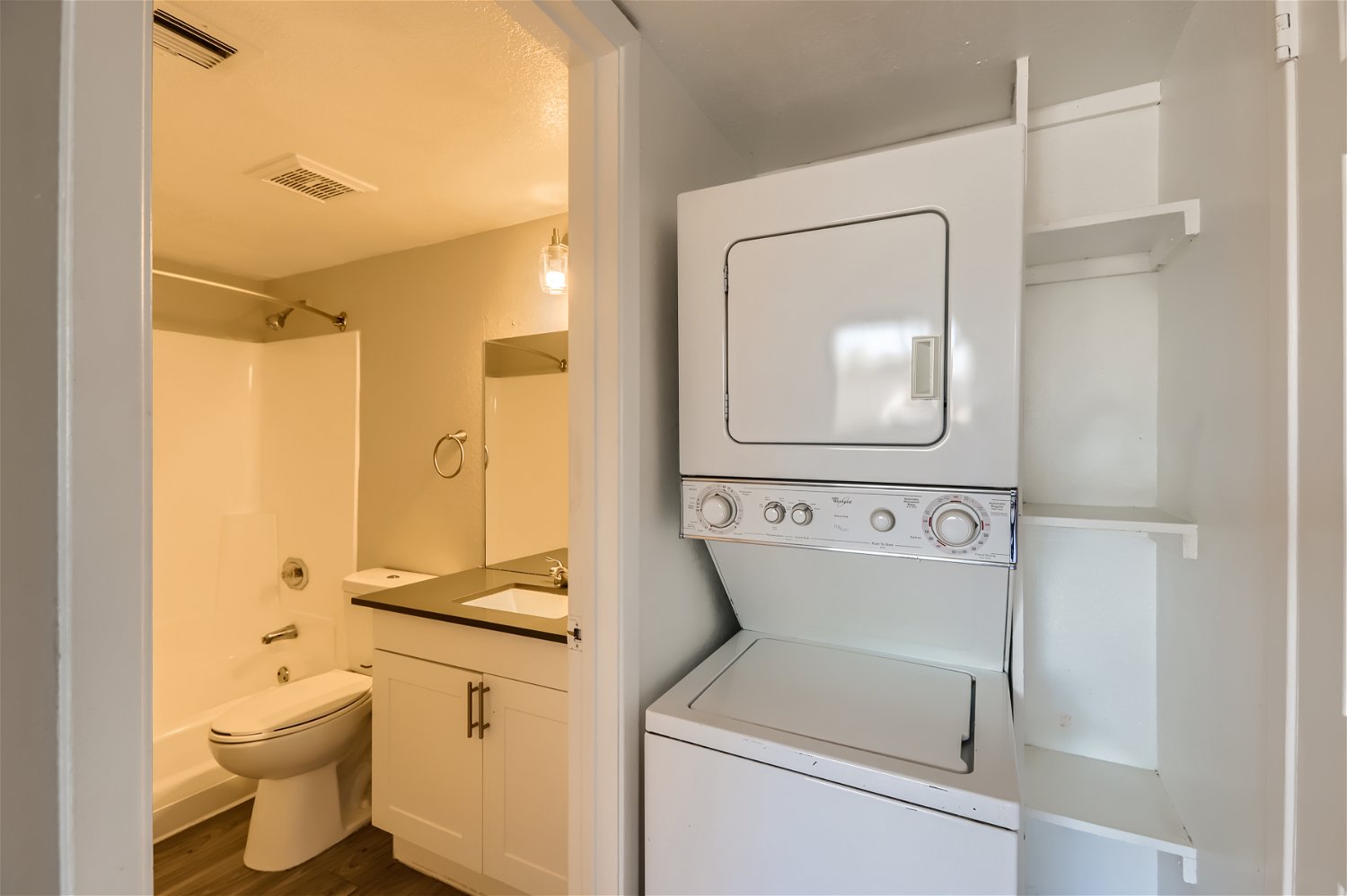 The bathroom with a washer and dryer in an enclave at Rise Trailside.