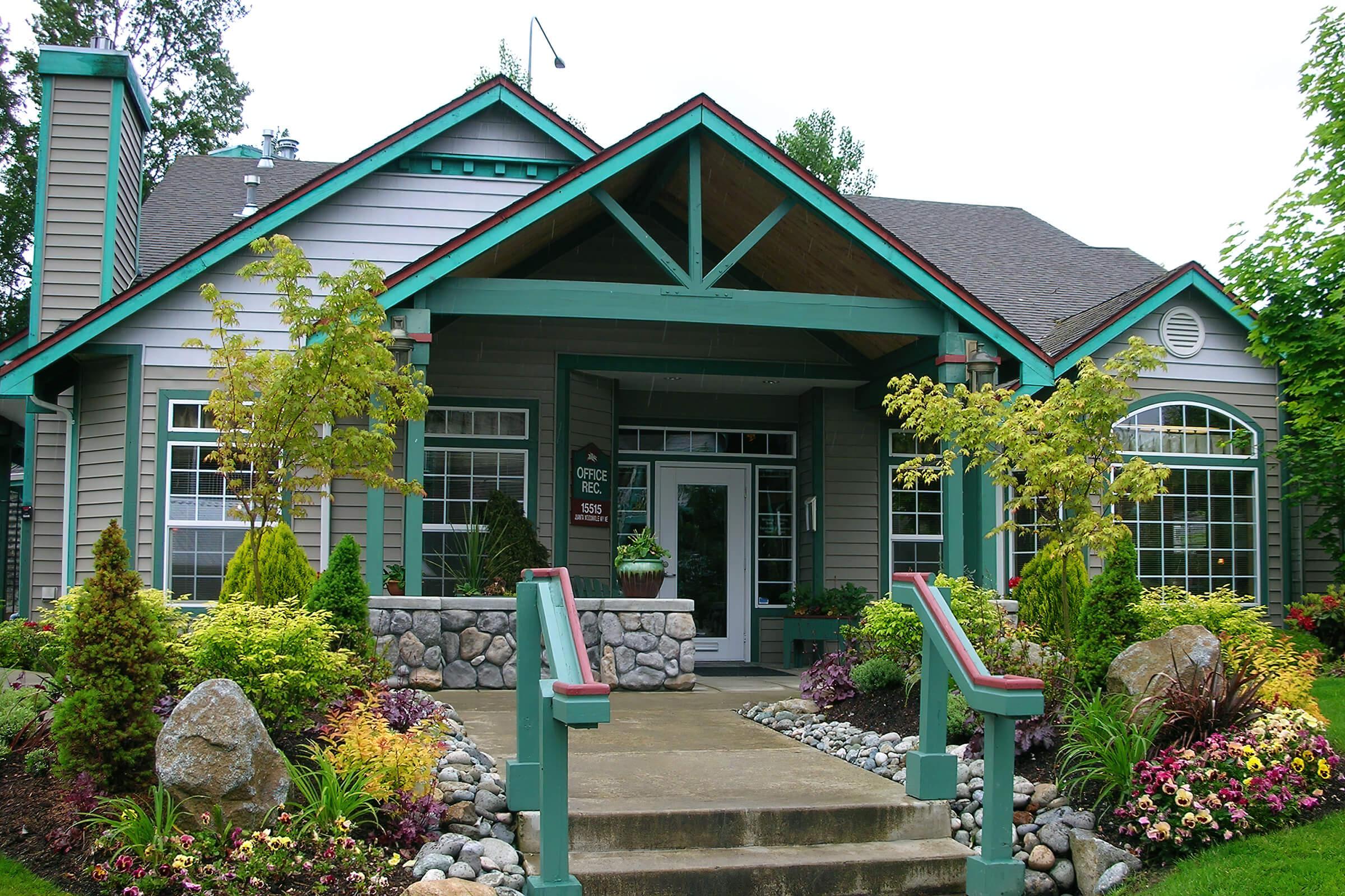 a close up of a flower garden in front of a house