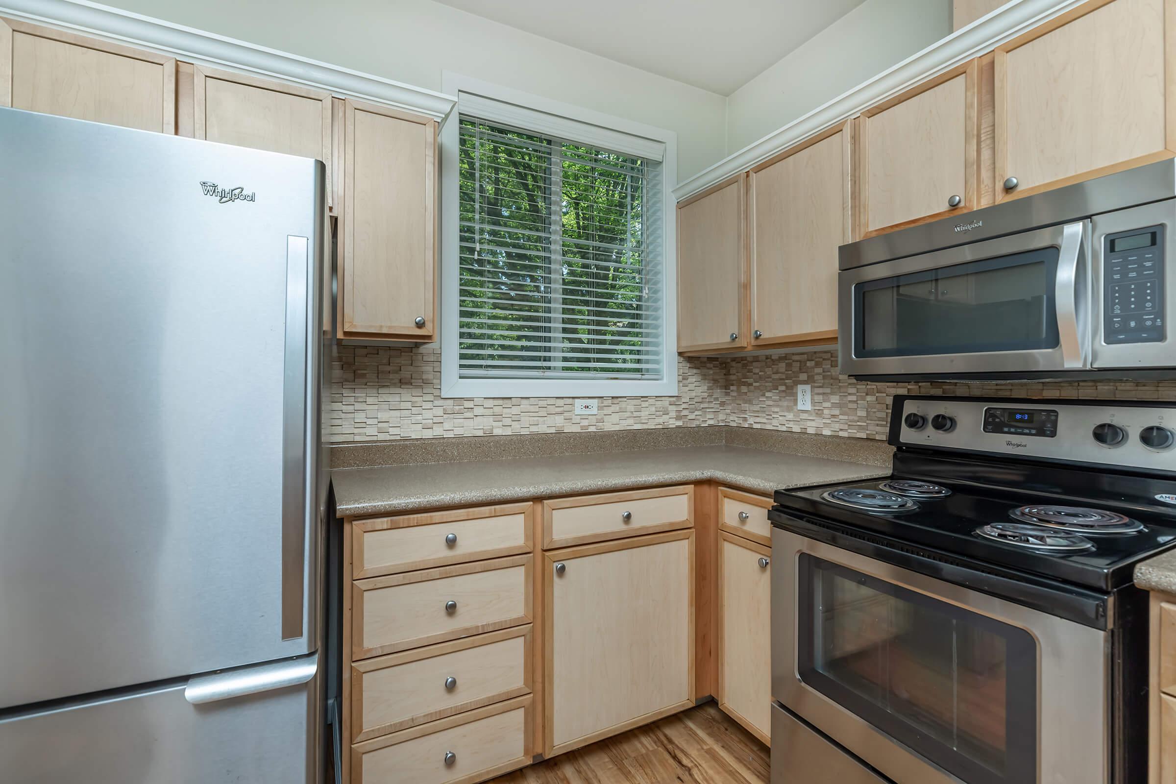 a stove top oven sitting inside of a kitchen with stainless steel appliances