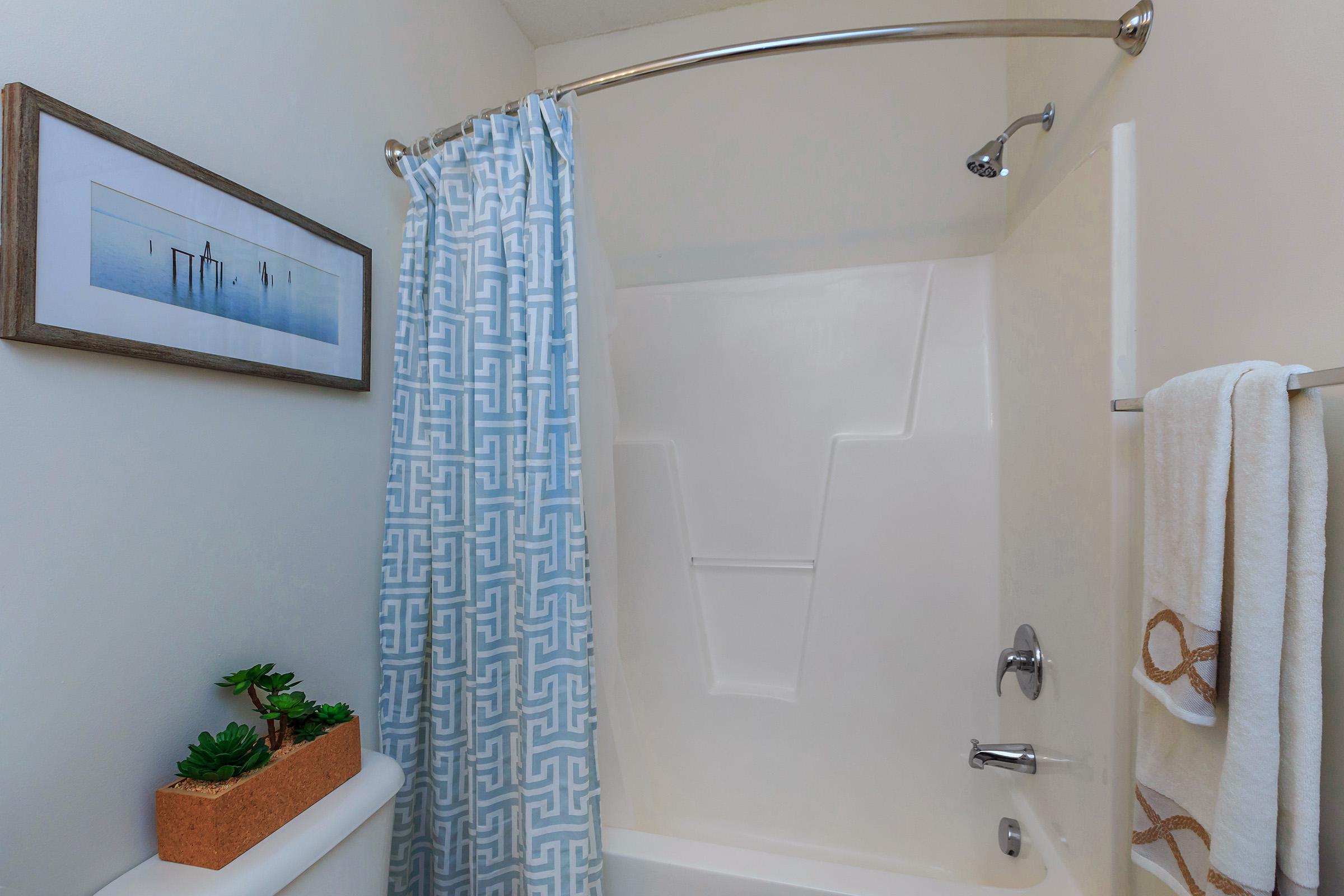 a white tub sitting next to a shower curtain