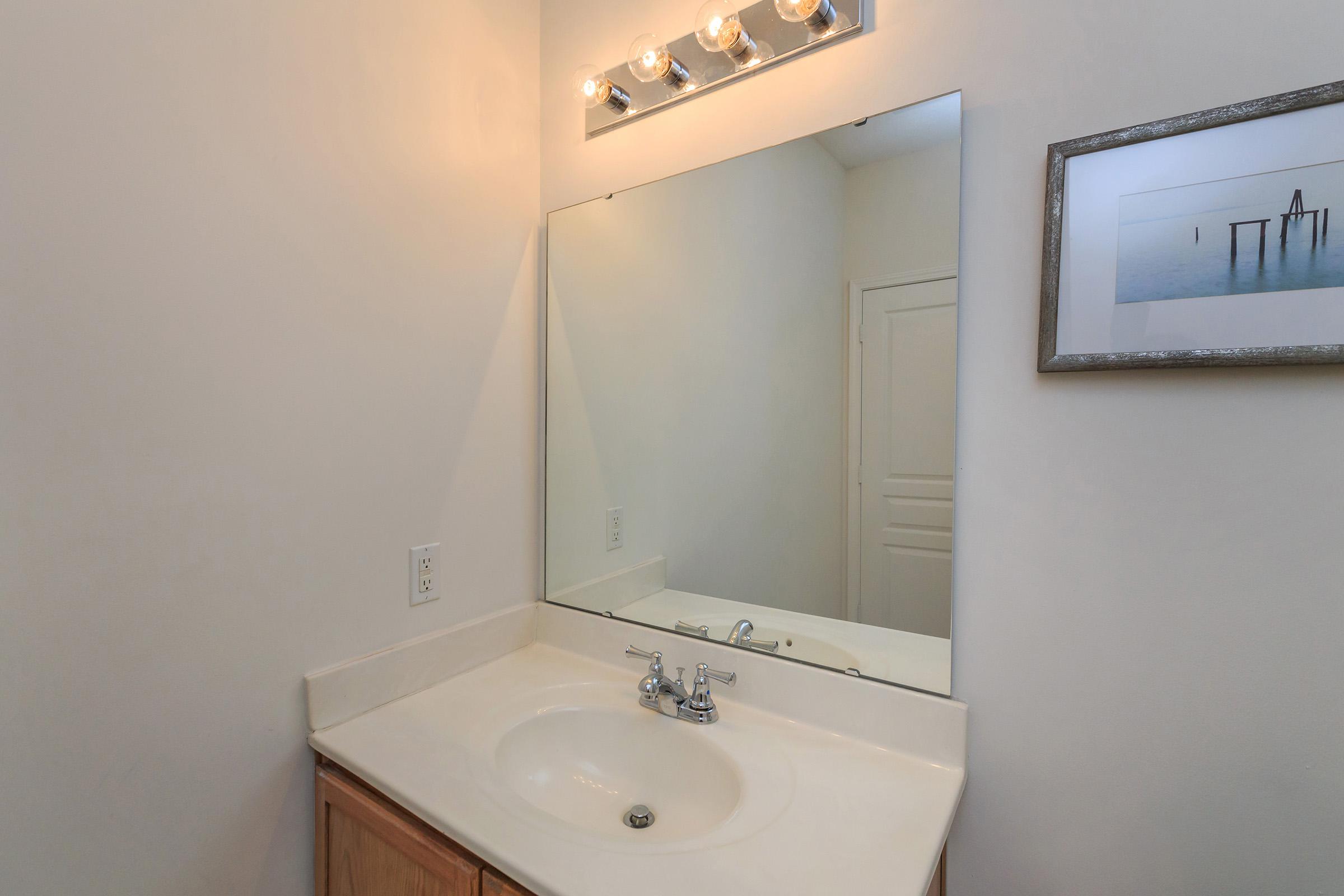 a white sink and a mirror