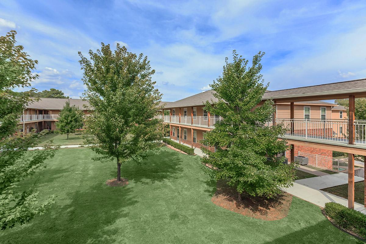 a large brick building with grass in front of a house