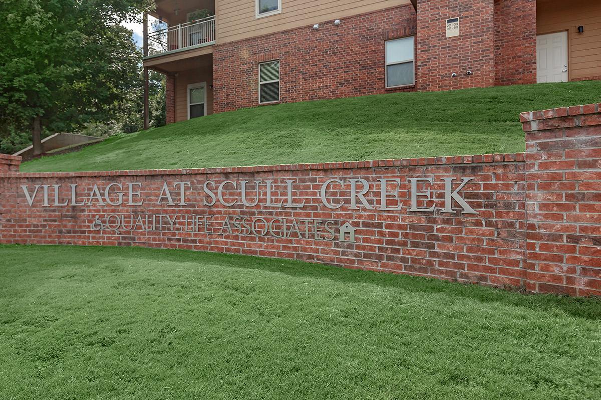 a large brick building with green grass