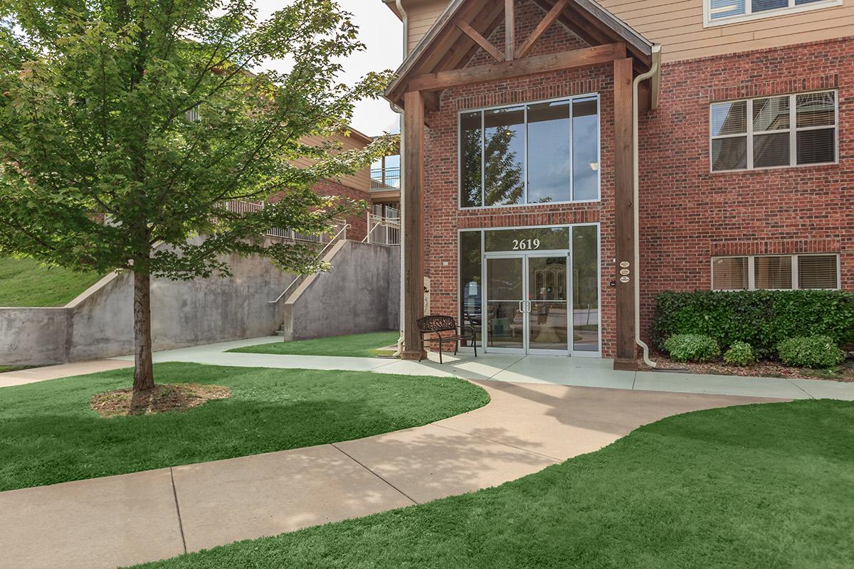 a large lawn in front of a brick building