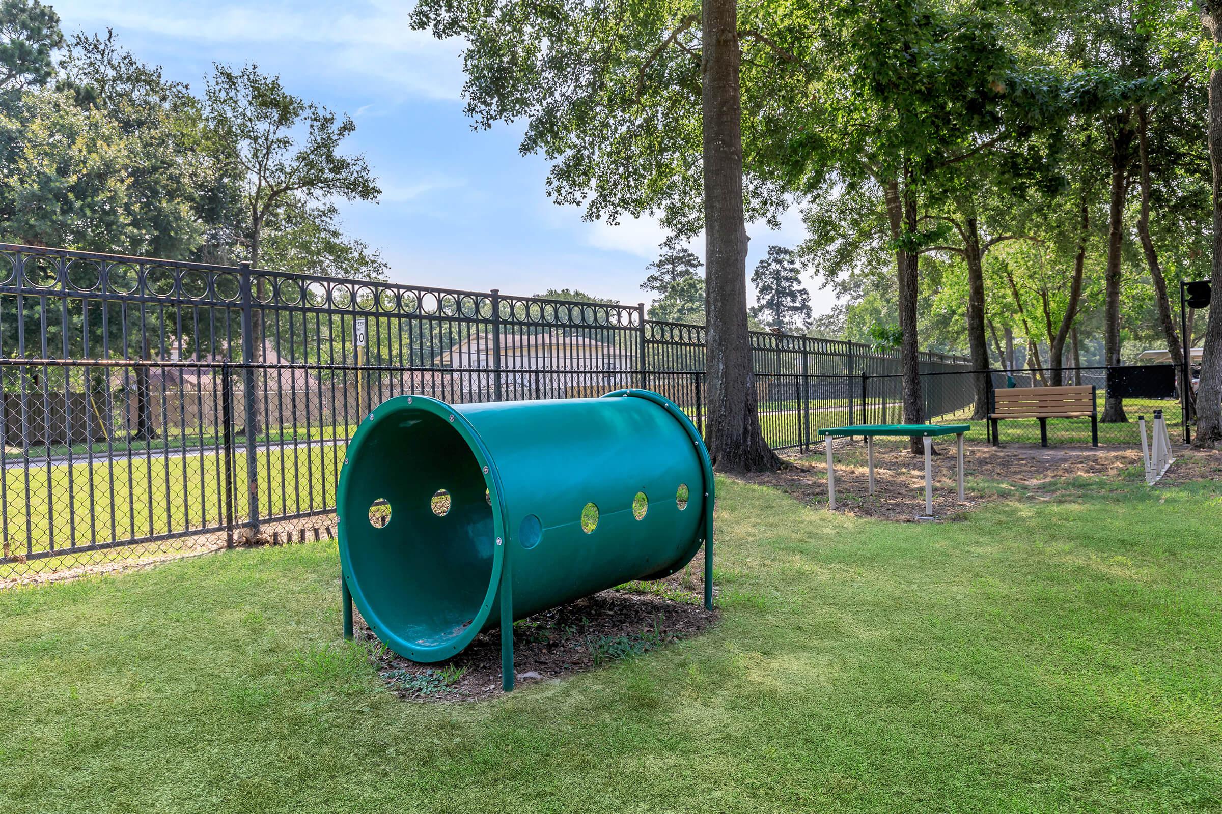 a large green field in front of a fence