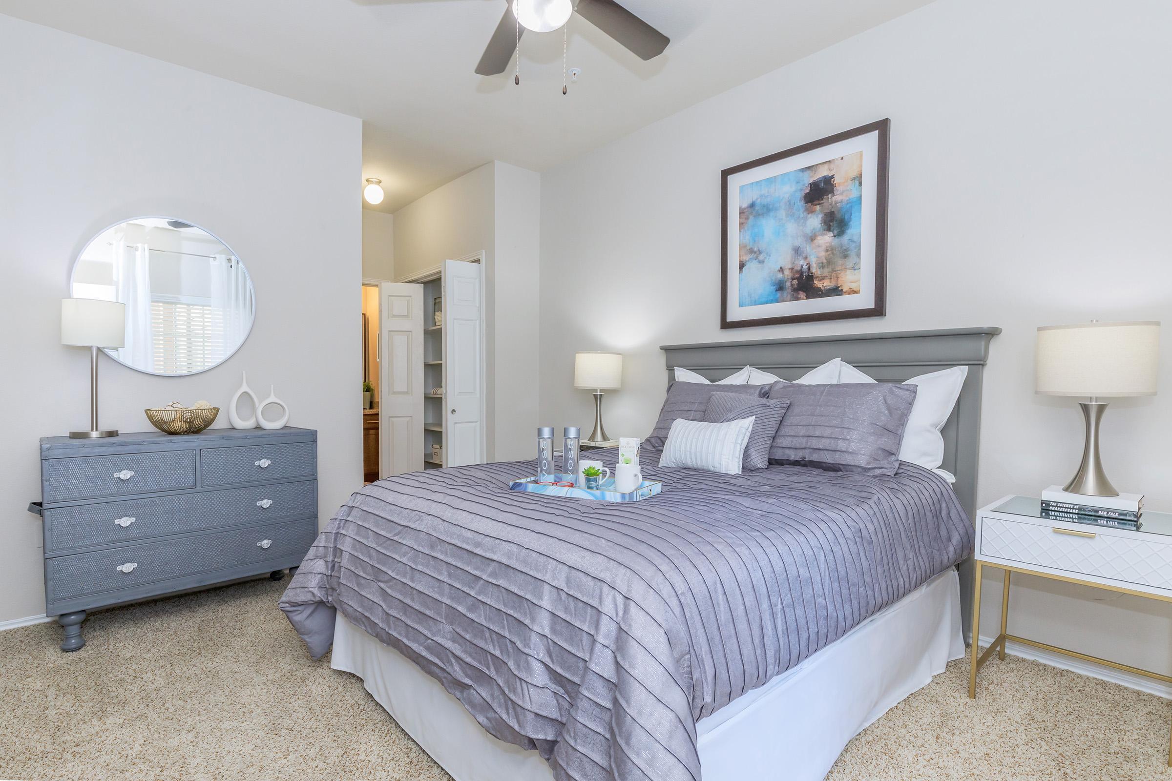 a bedroom with a bed and desk in a room