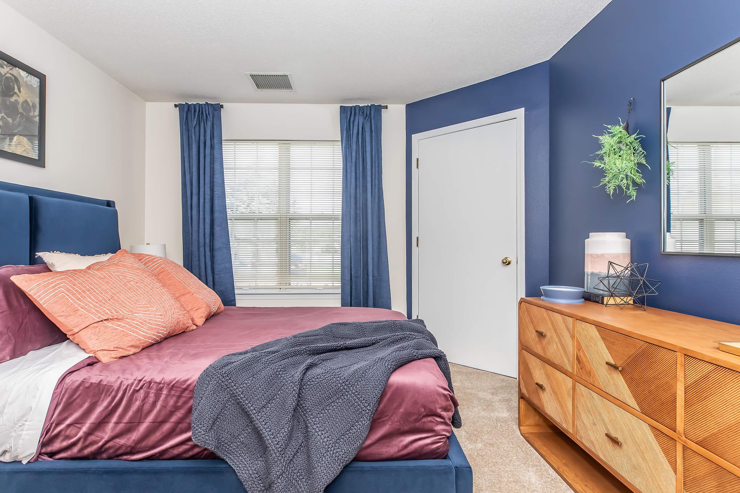 a bedroom with a bed and a chair in a room