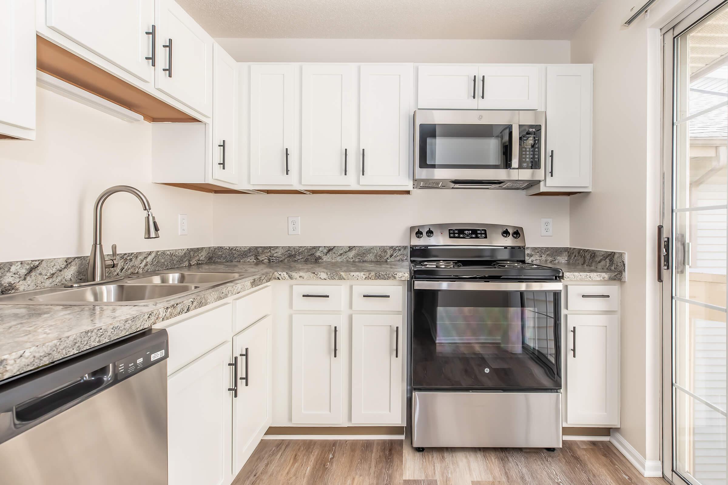 a kitchen with a stove a sink and a microwave