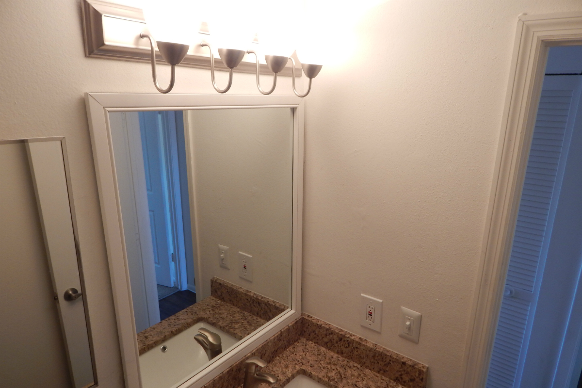 a white sink sitting under a mirror