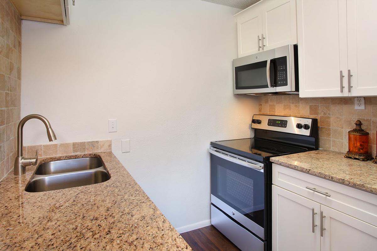 a kitchen with a stove a sink and a microwave