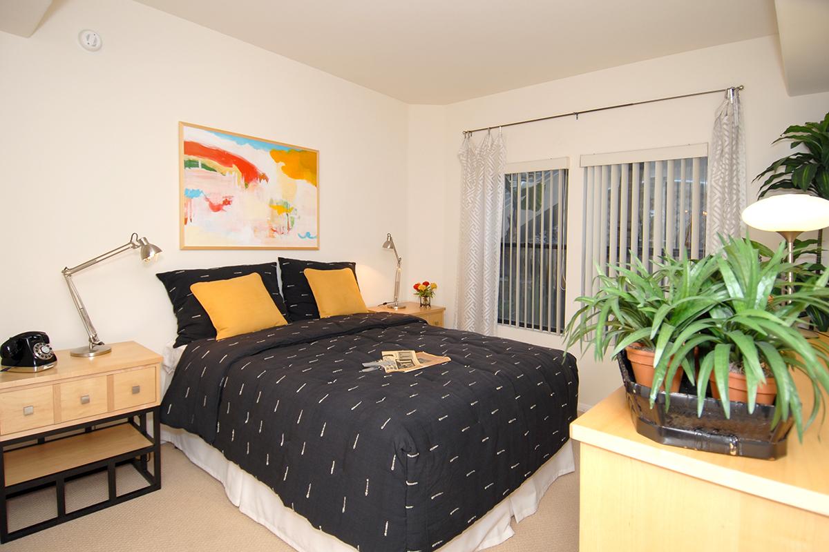 a bedroom with a bed and desk in a room