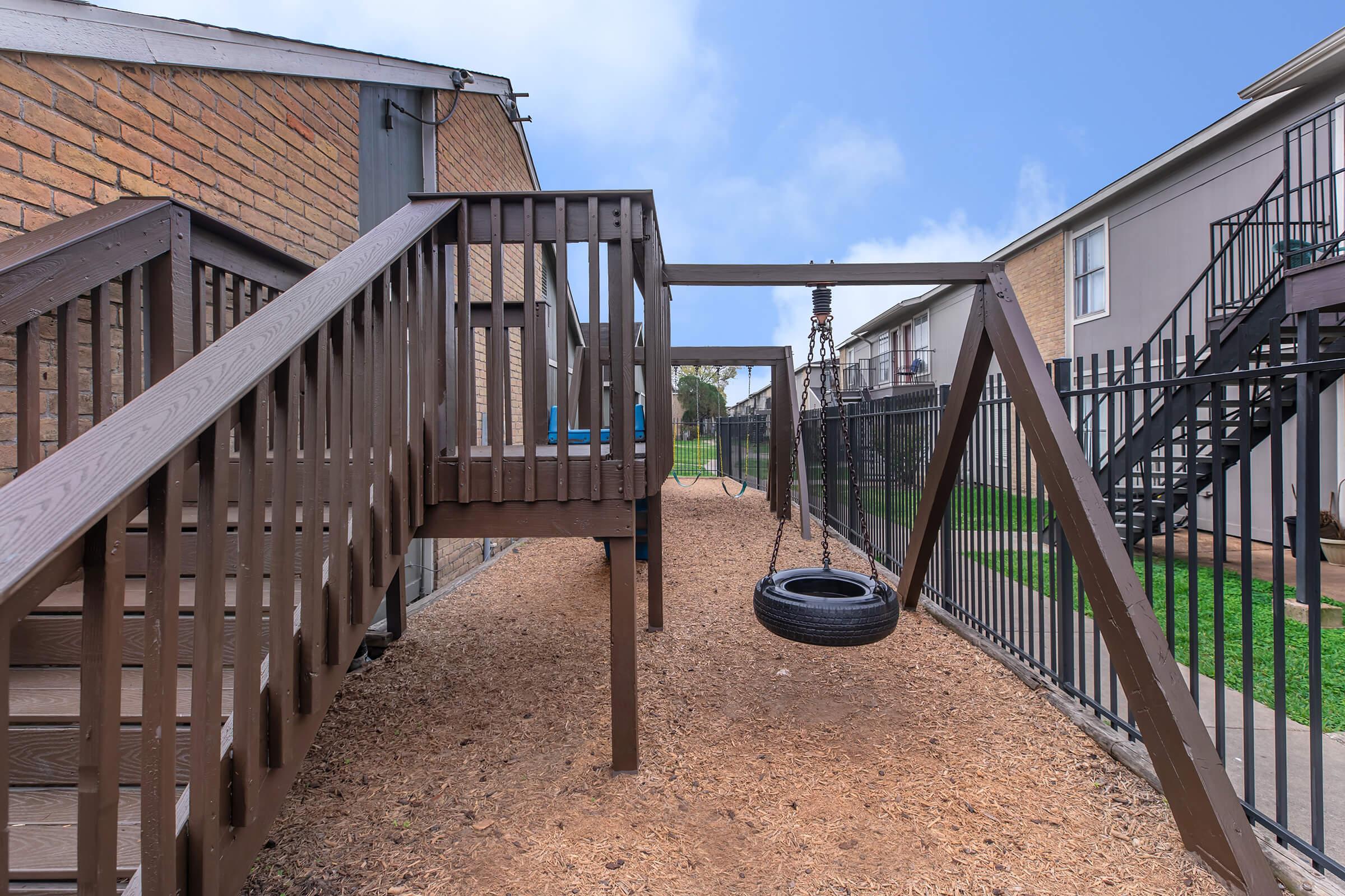 a row of wooden benches sitting on the side of a fence