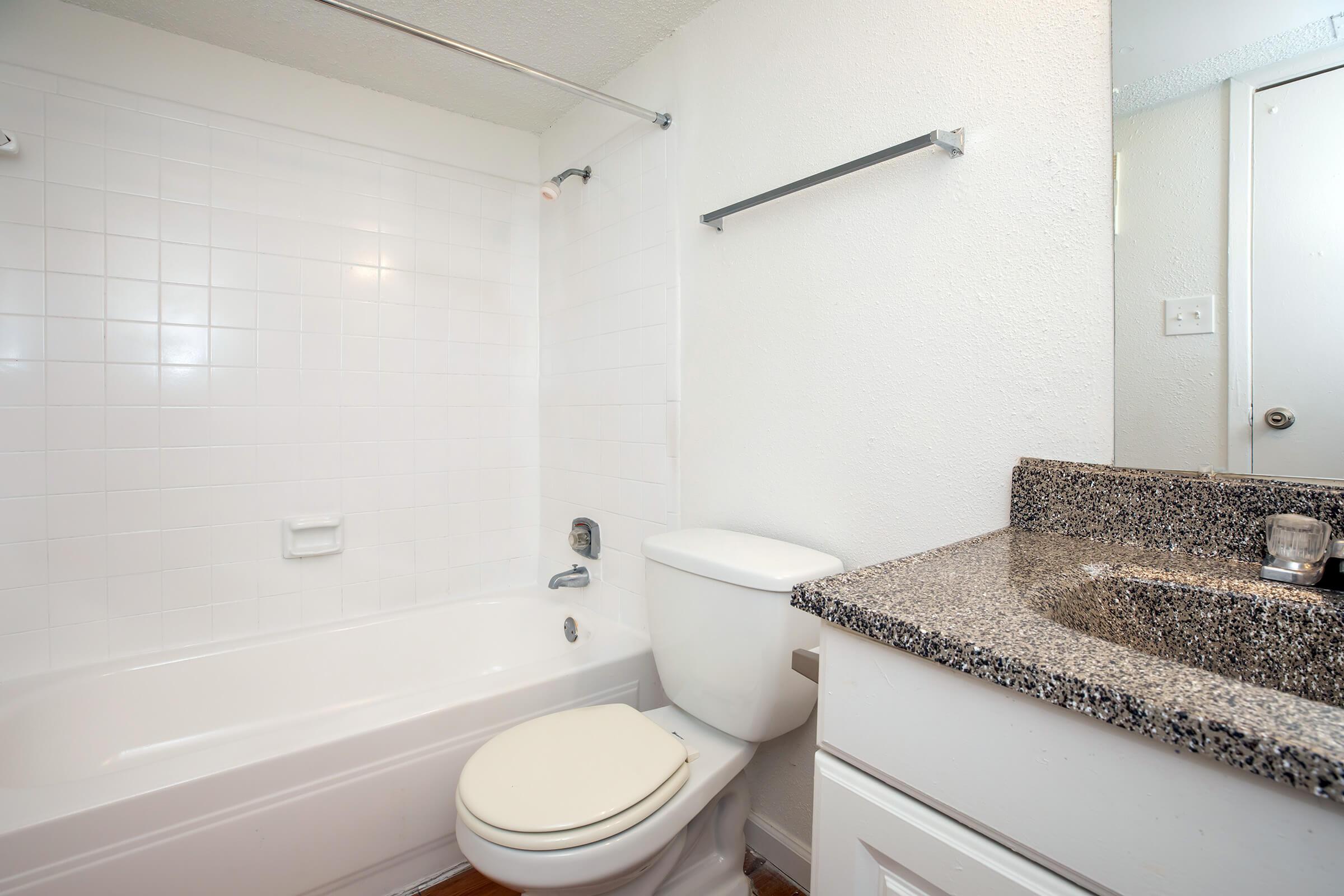 a white sink sitting next to a shower