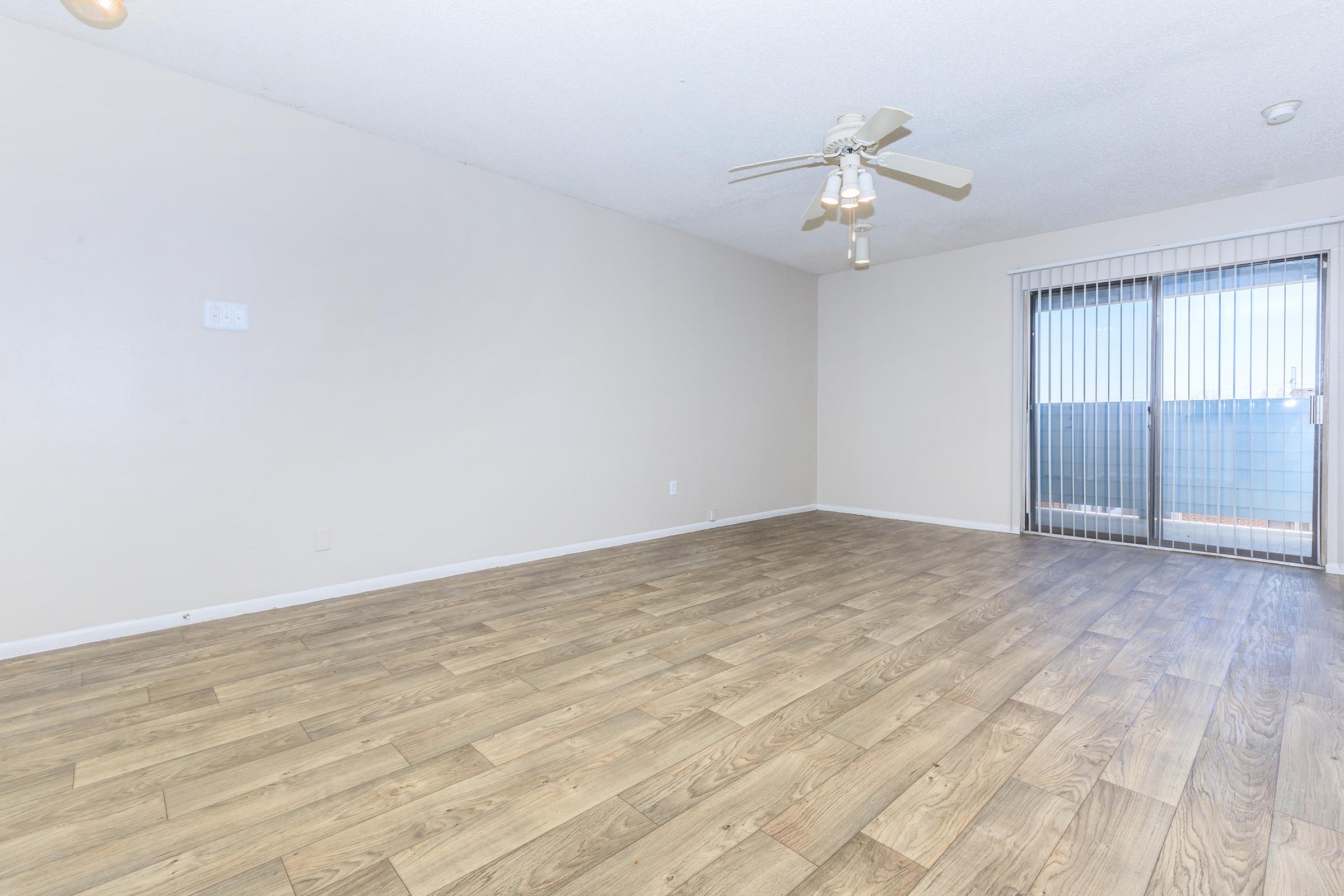 SPACIOUS LIVING ROOM WITH A CEILING FAN IN SAN ANTONIO, TX