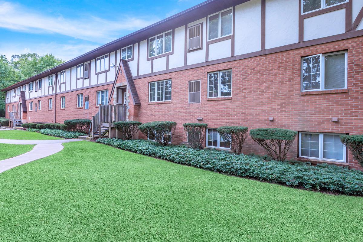 a large lawn in front of a brick building