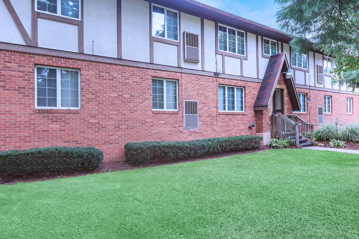 a large lawn in front of a brick building