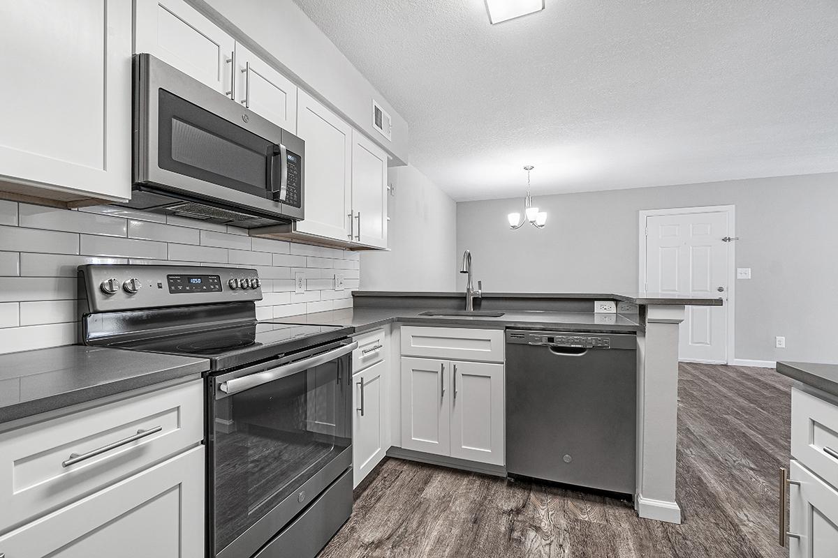 a kitchen with white cabinets and a black stove