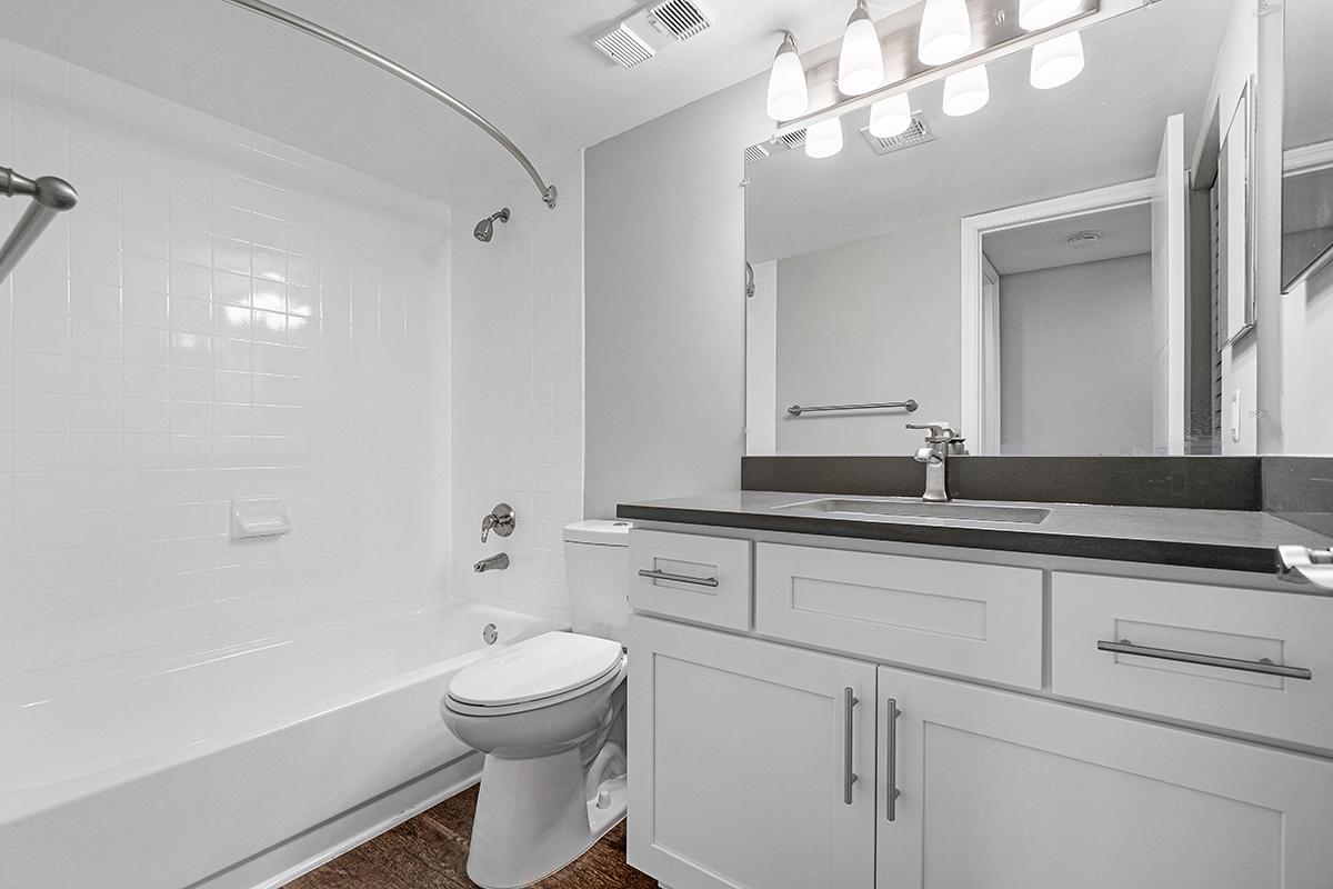 a white sink sitting under a mirror