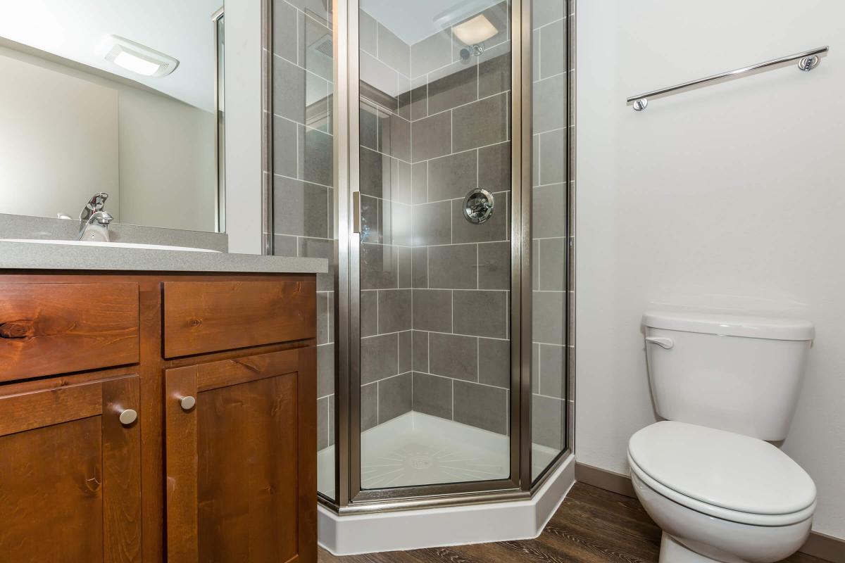 a white sink sitting next to a shower