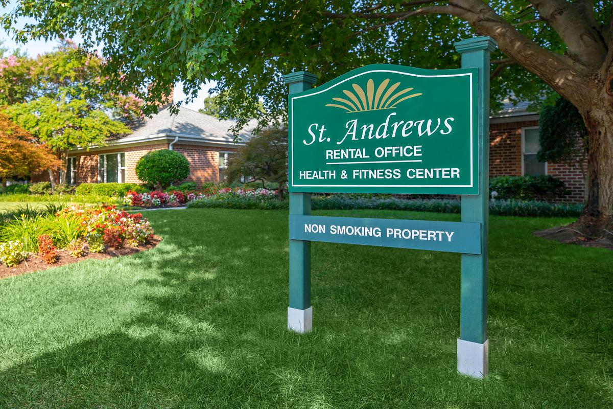 a white sign with red and green grass