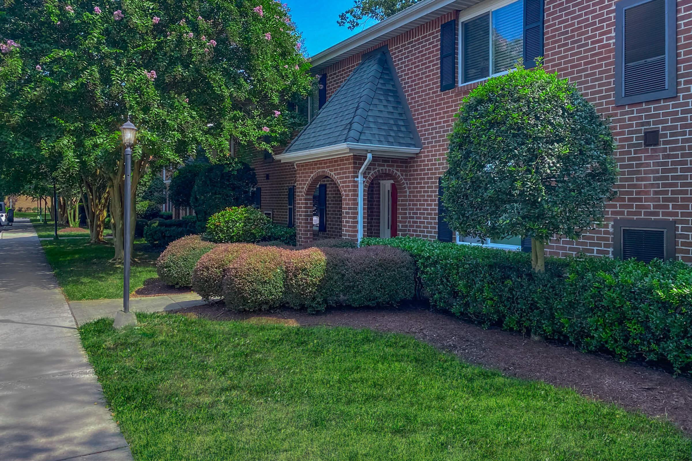 a large lawn in front of a brick building