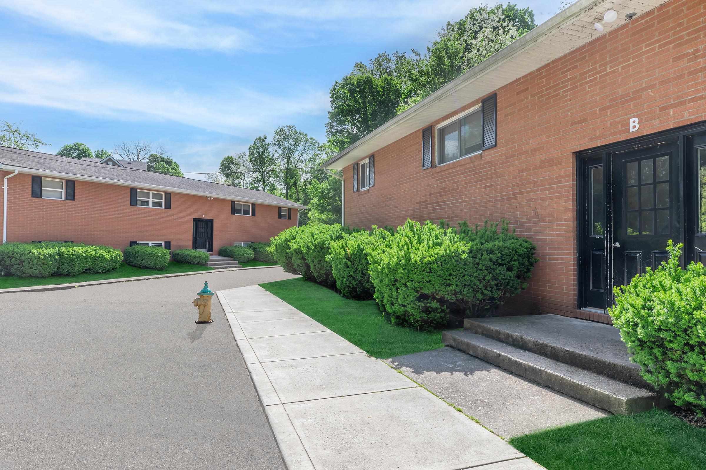 a large brick building with grass in front of a house