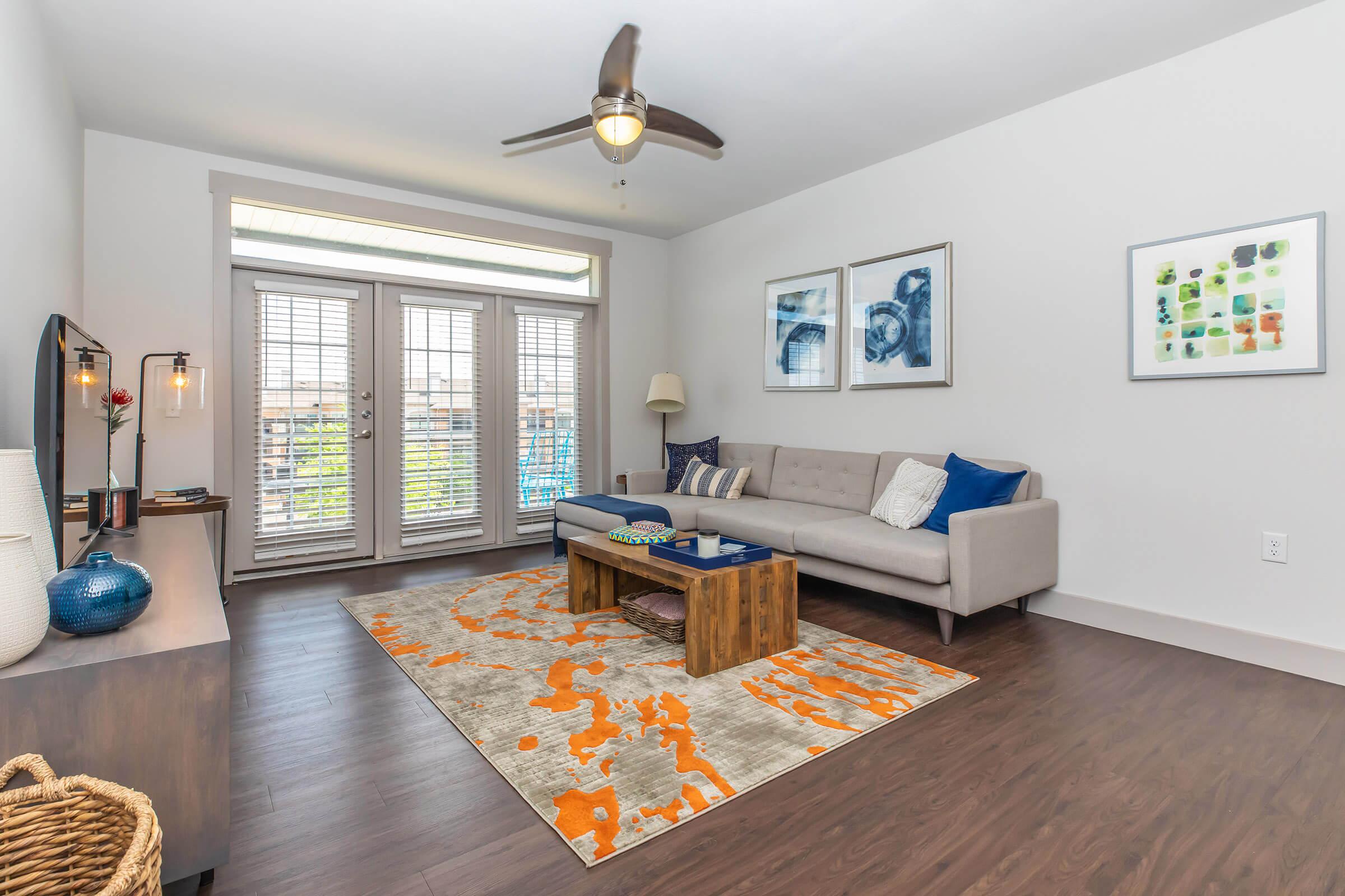 a living room filled with furniture and a wooden floor