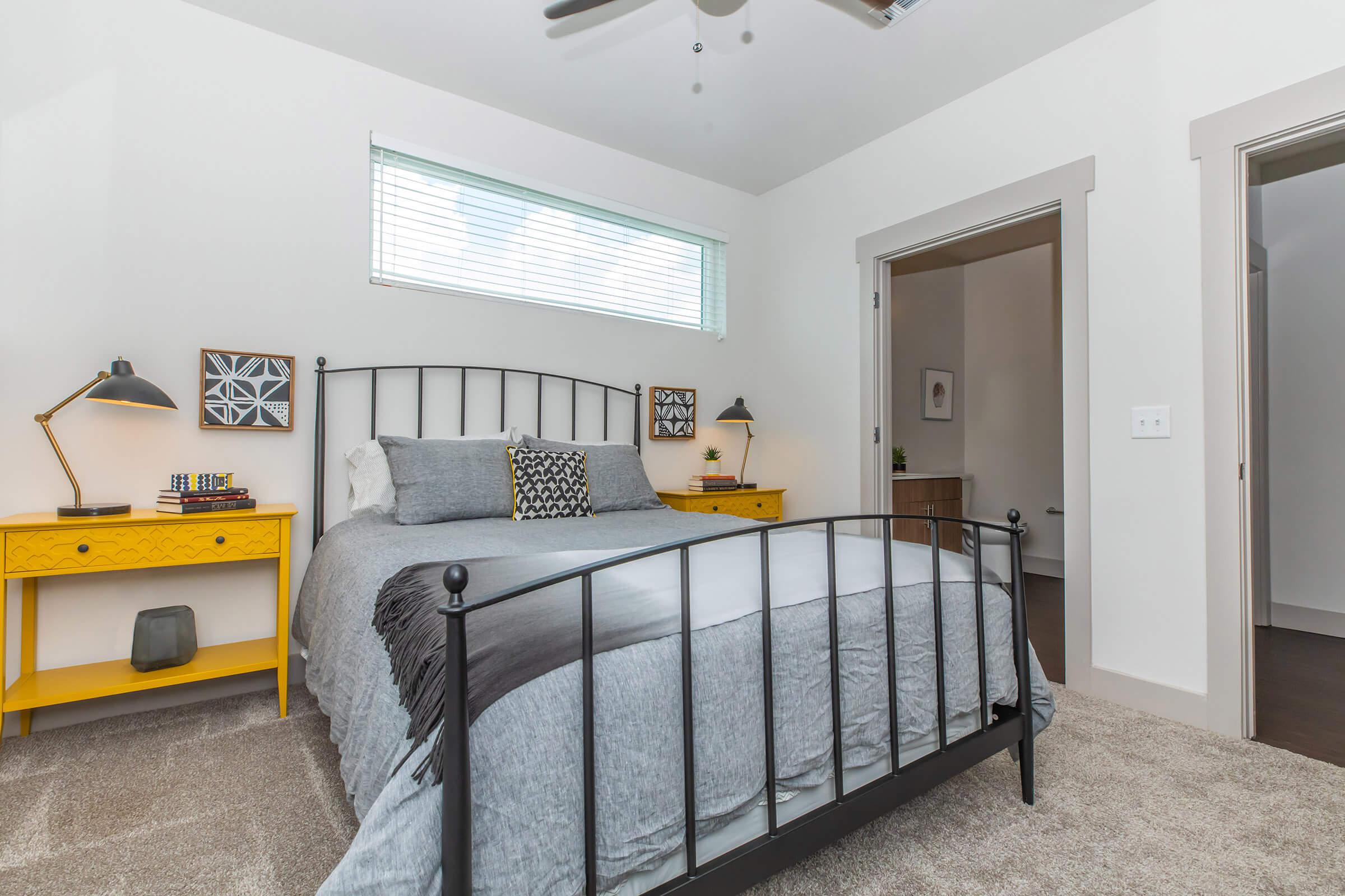 a furnished bedroom with wooden night tables