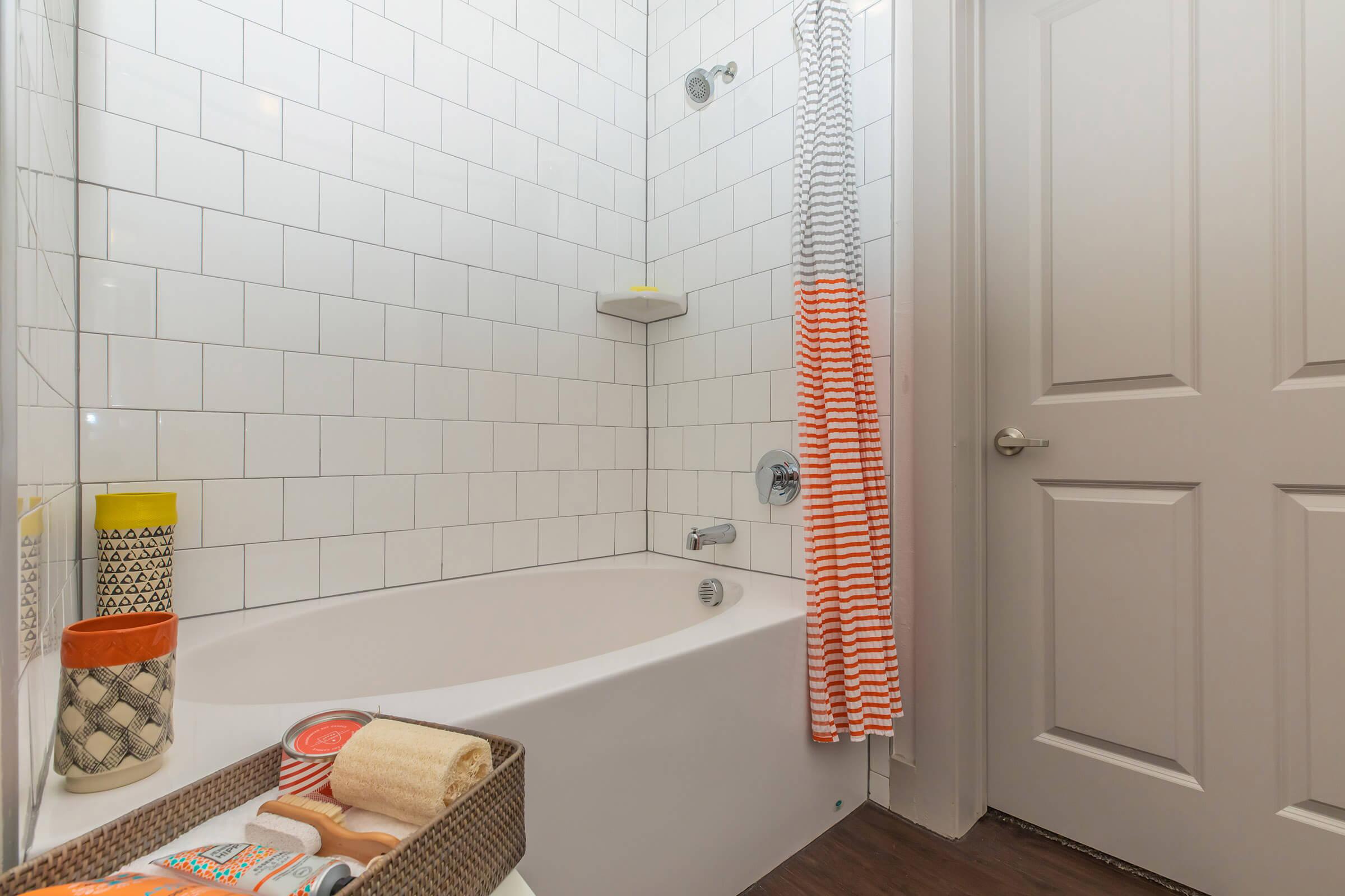 a shower with a pink and white shower curtain