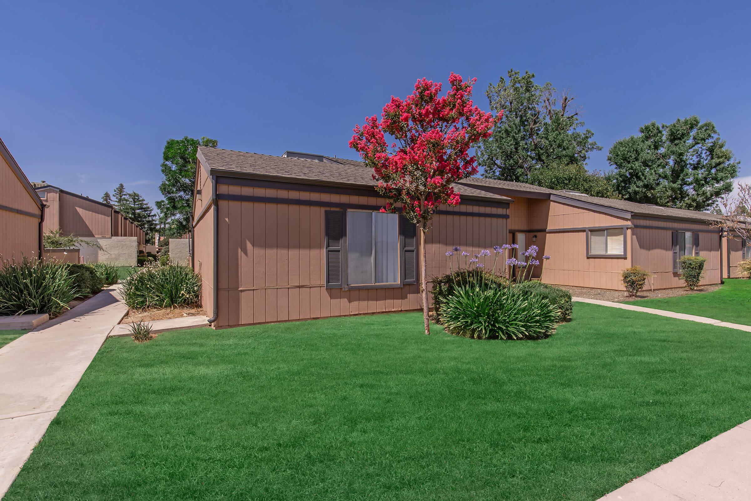 a house with a lawn in front of a brick building