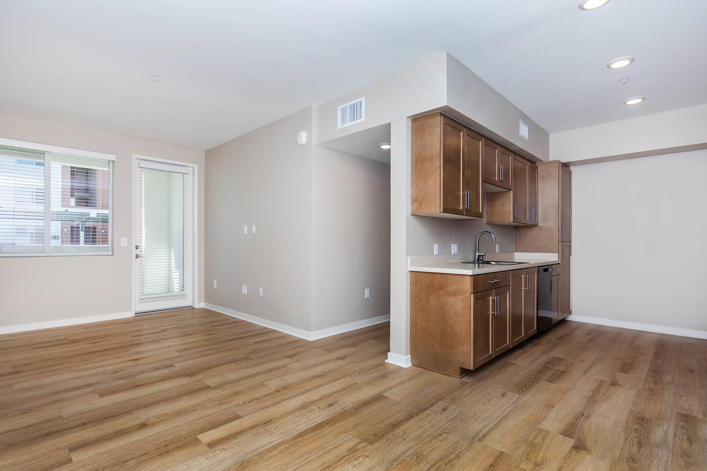 a kitchen with wooden cabinets and a wood floor