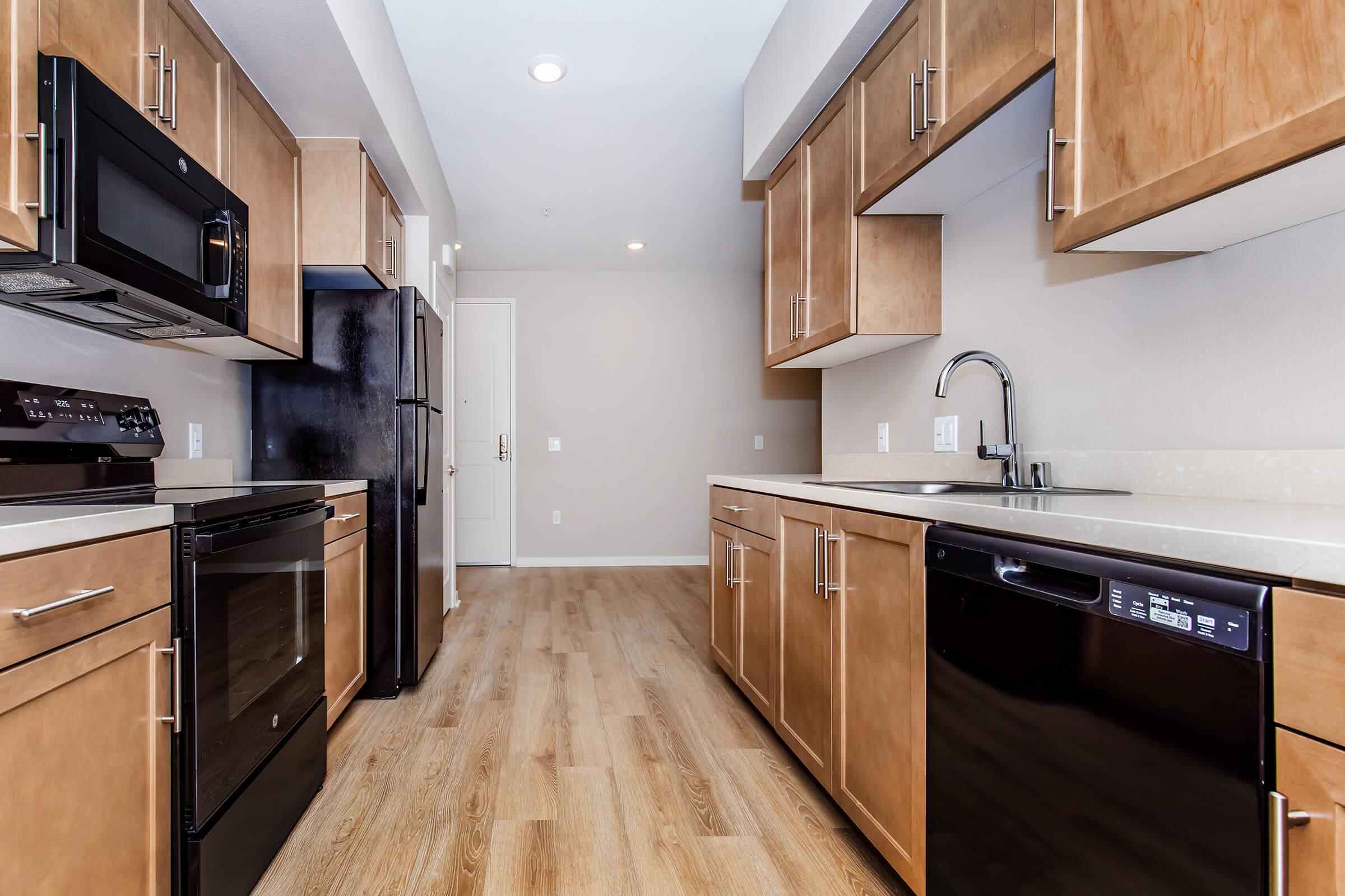 a modern kitchen with stainless steel appliances and wooden cabinets