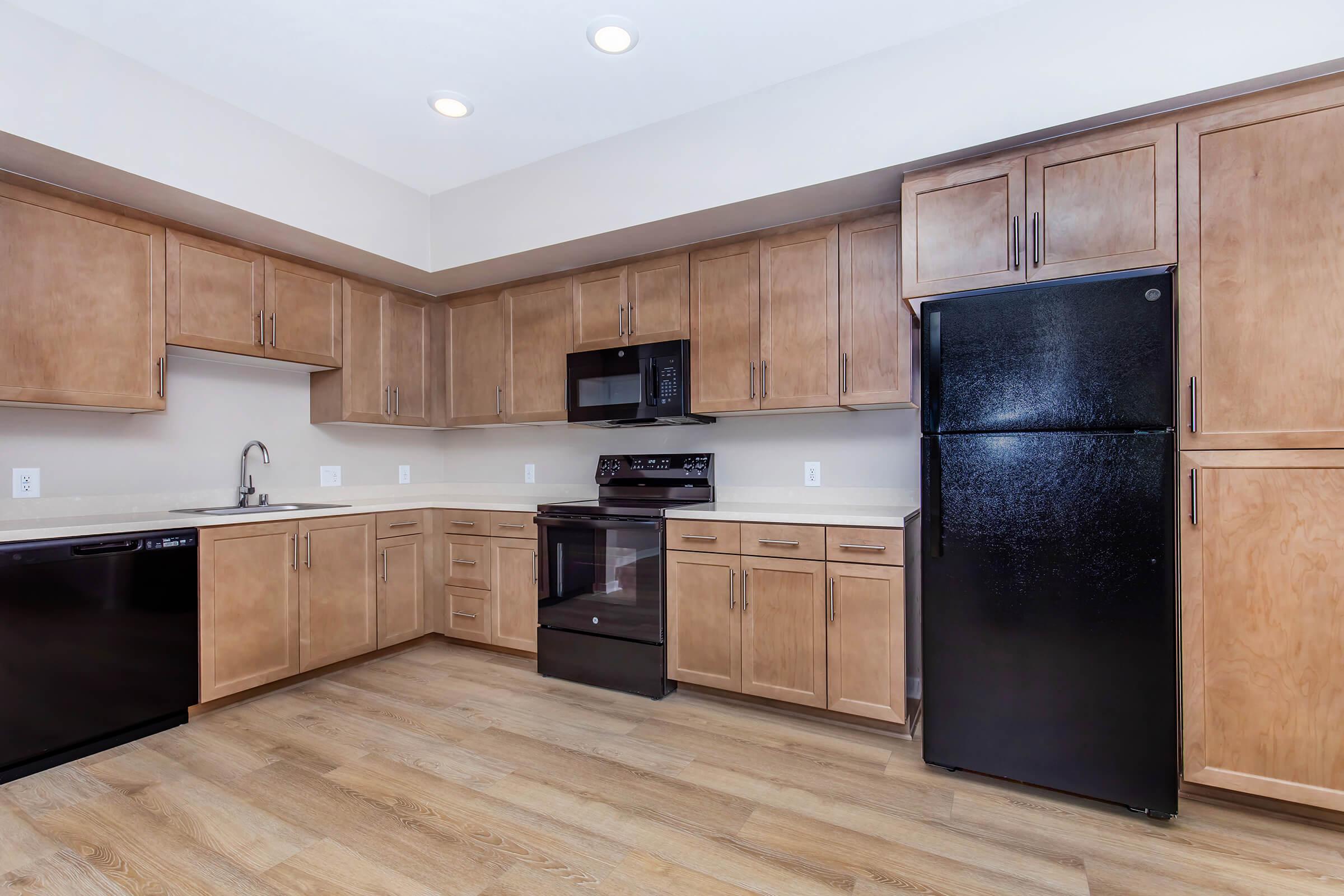 a large kitchen with stainless steel appliances and wooden cabinets