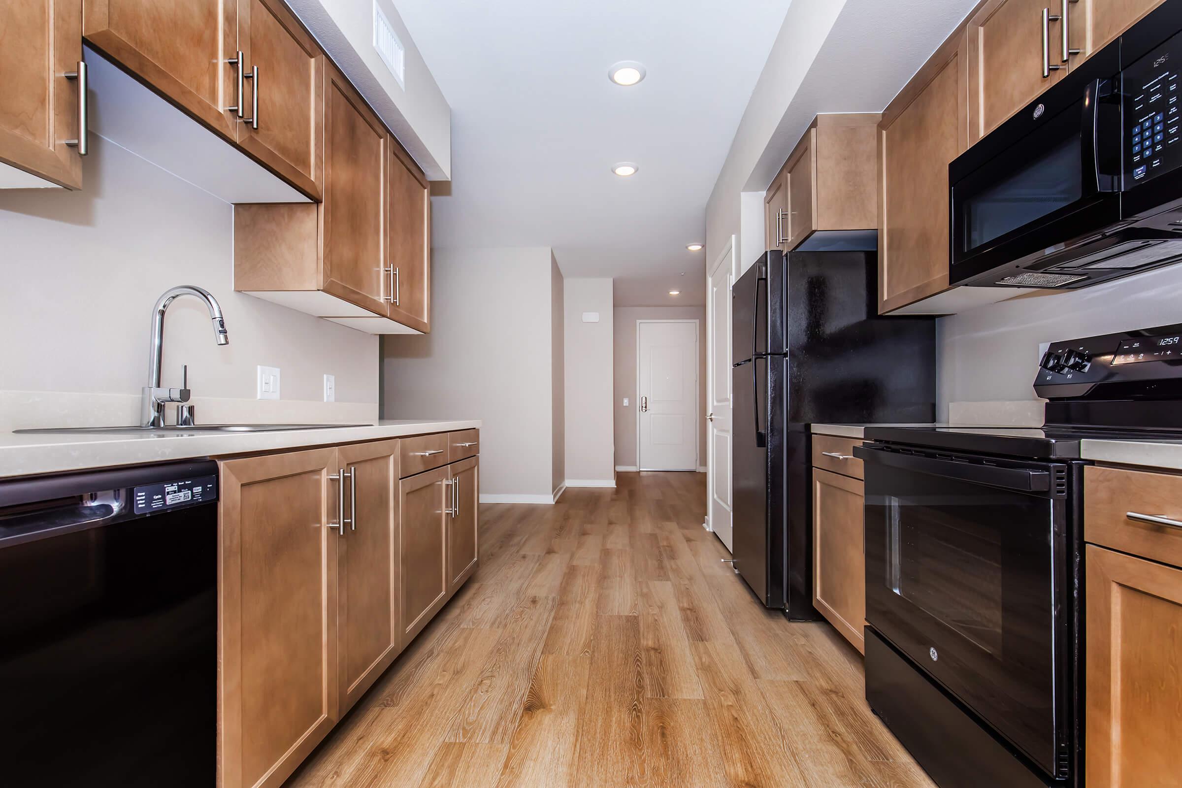 a large kitchen with stainless steel appliances and wooden cabinets