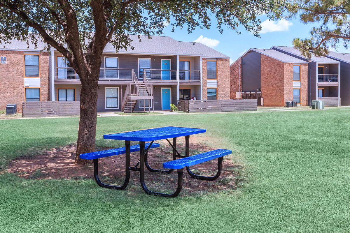 a blue bench in front of a brick building