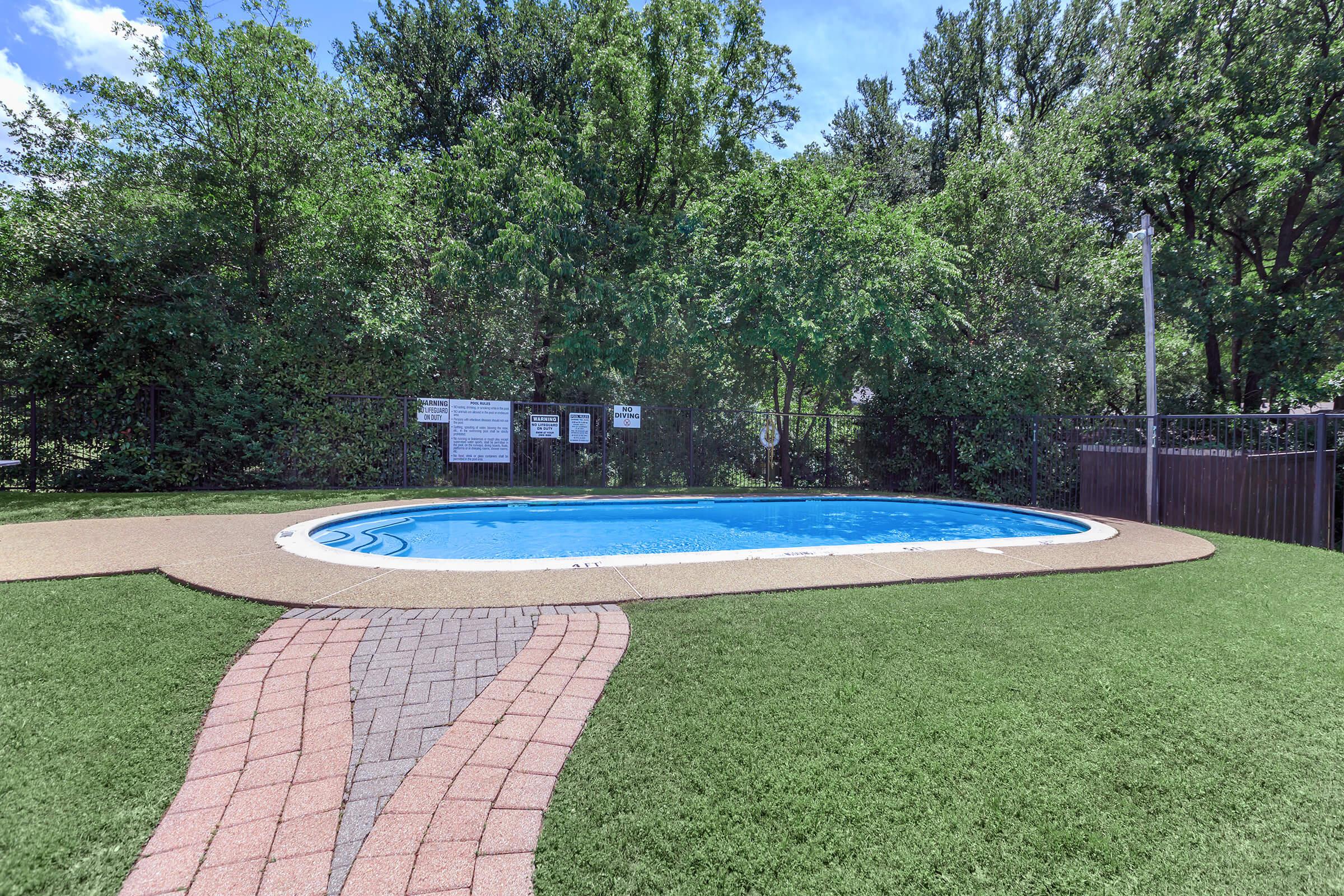 a pool with grass and trees