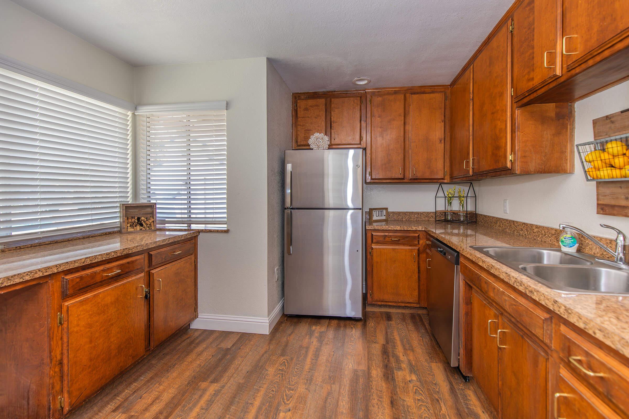 a large kitchen with stainless steel appliances and wooden cabinets