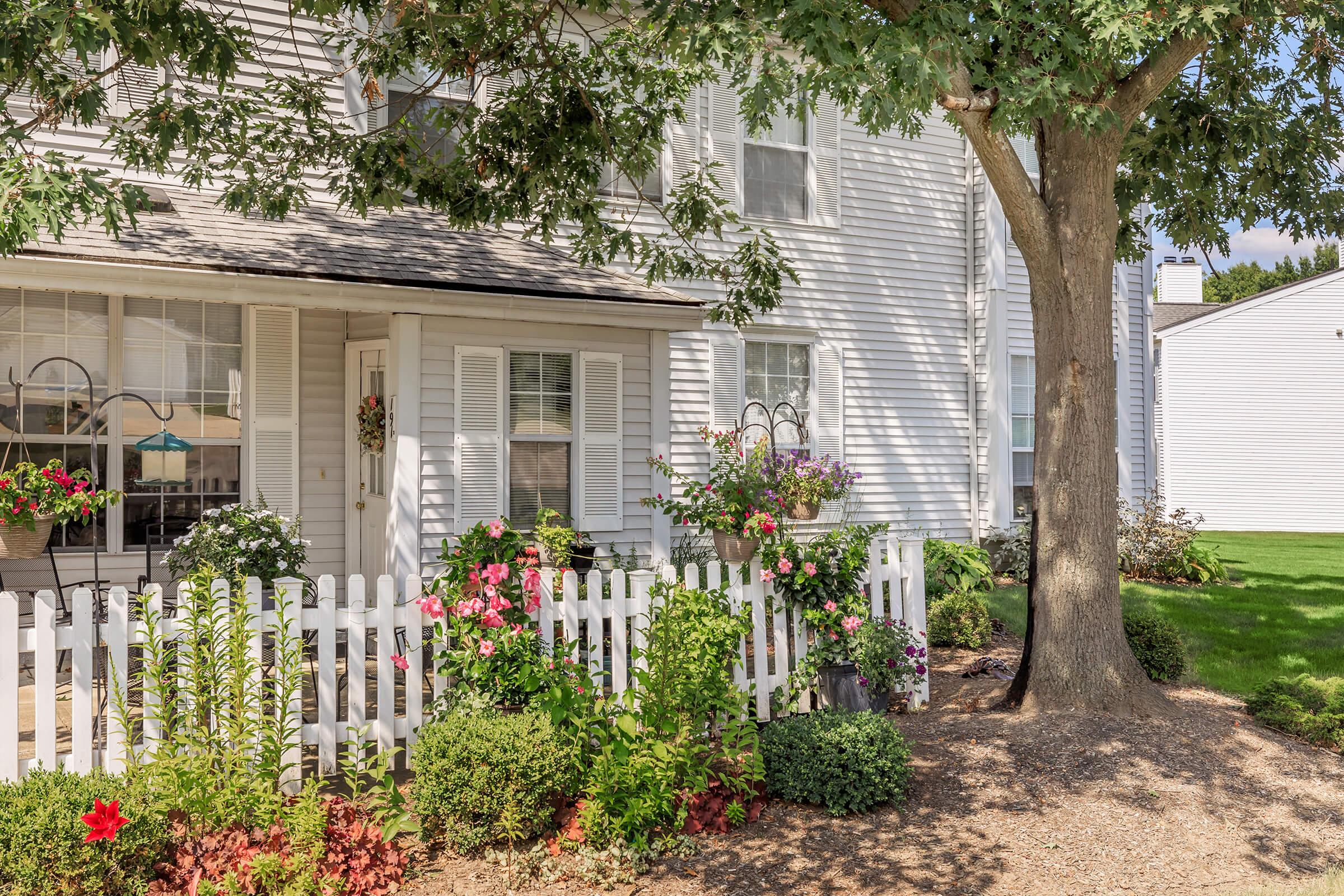 a close up of a flower garden in front of a house