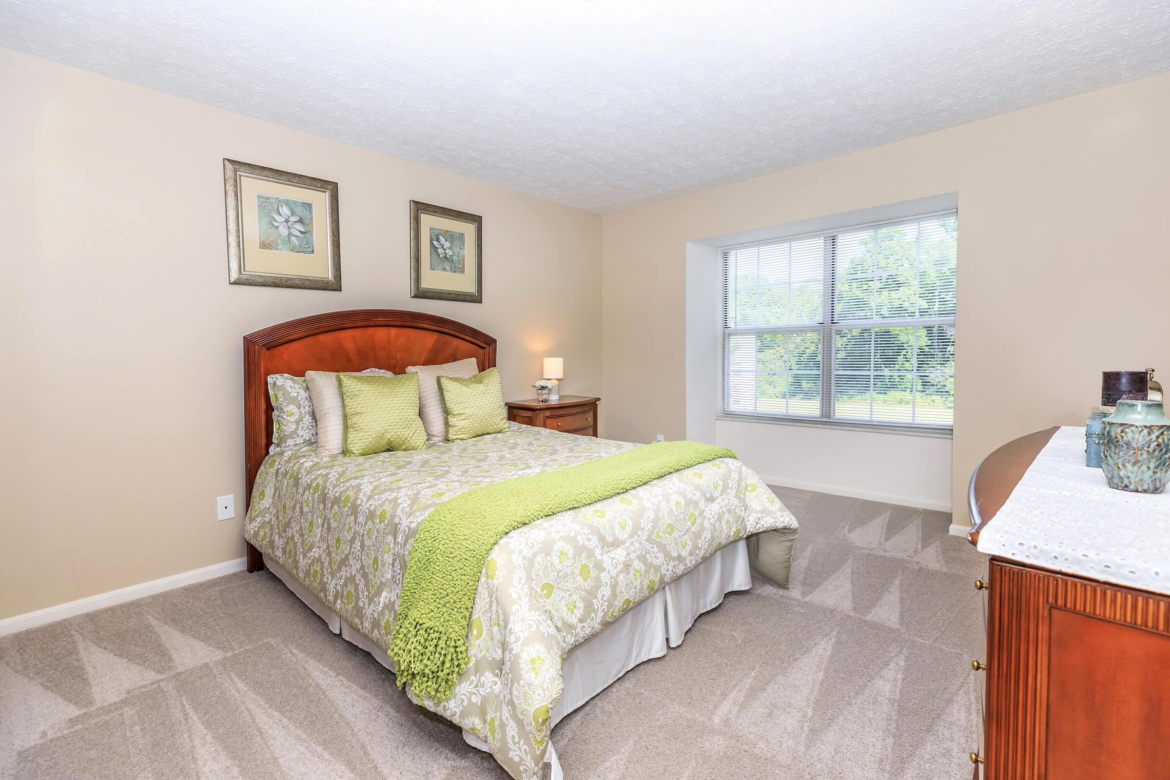 a bedroom with a bed and desk in a hotel room